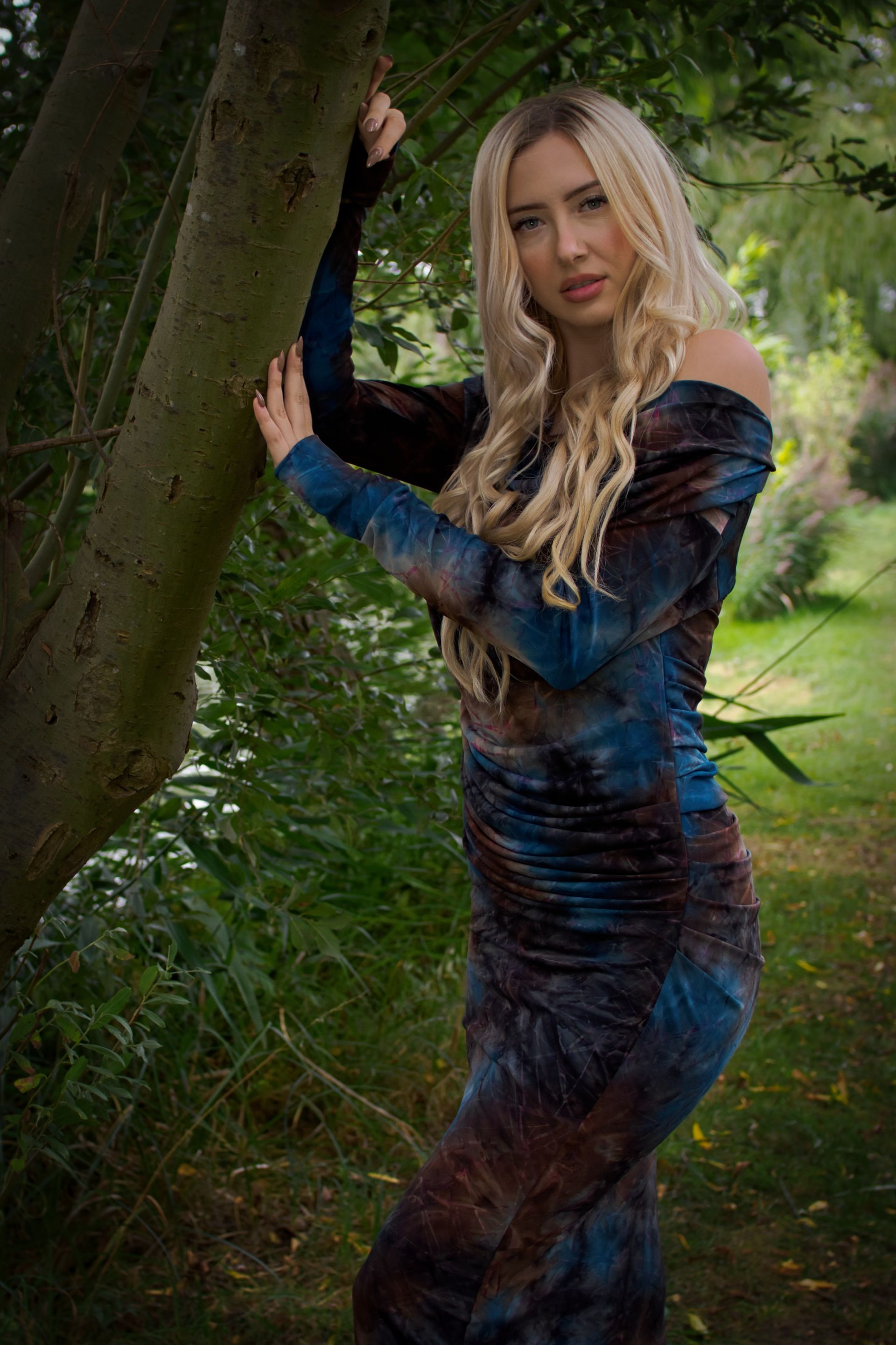 A female model posed by a tree
