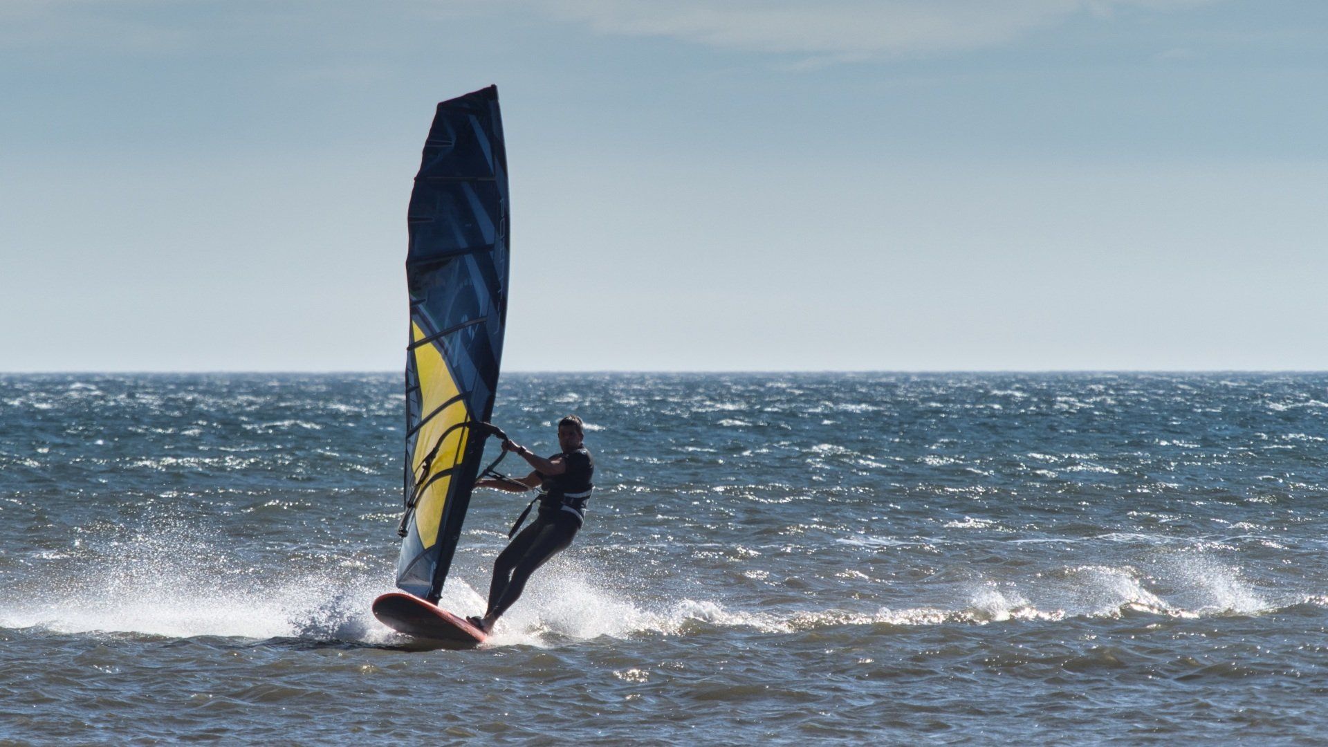 Windsurfer, Fraisethorpe beach by Derek Smith a windsurfer at speed skimming the waves