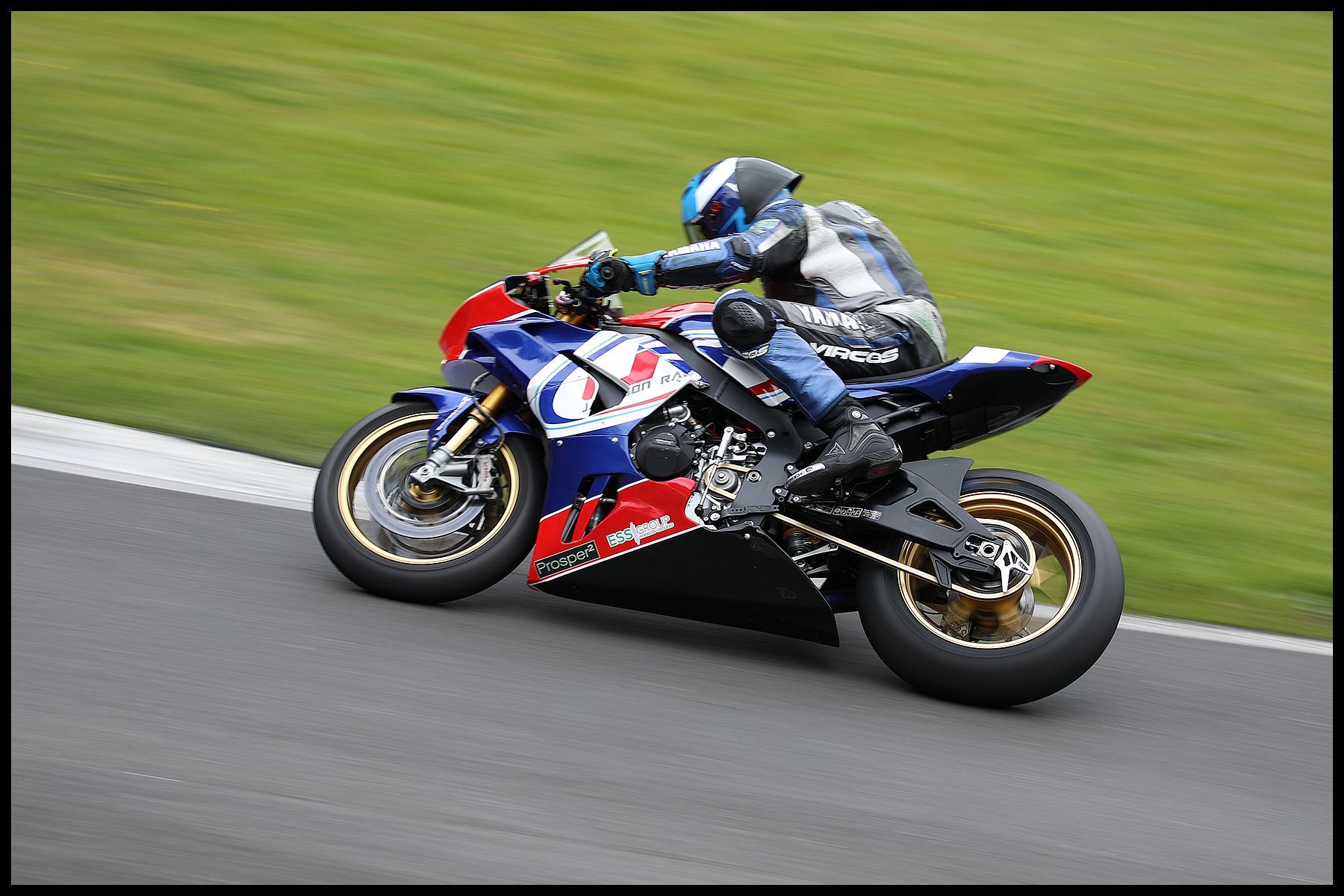 Panning by Paul Malley a racing motorcycle speeding along a race track
