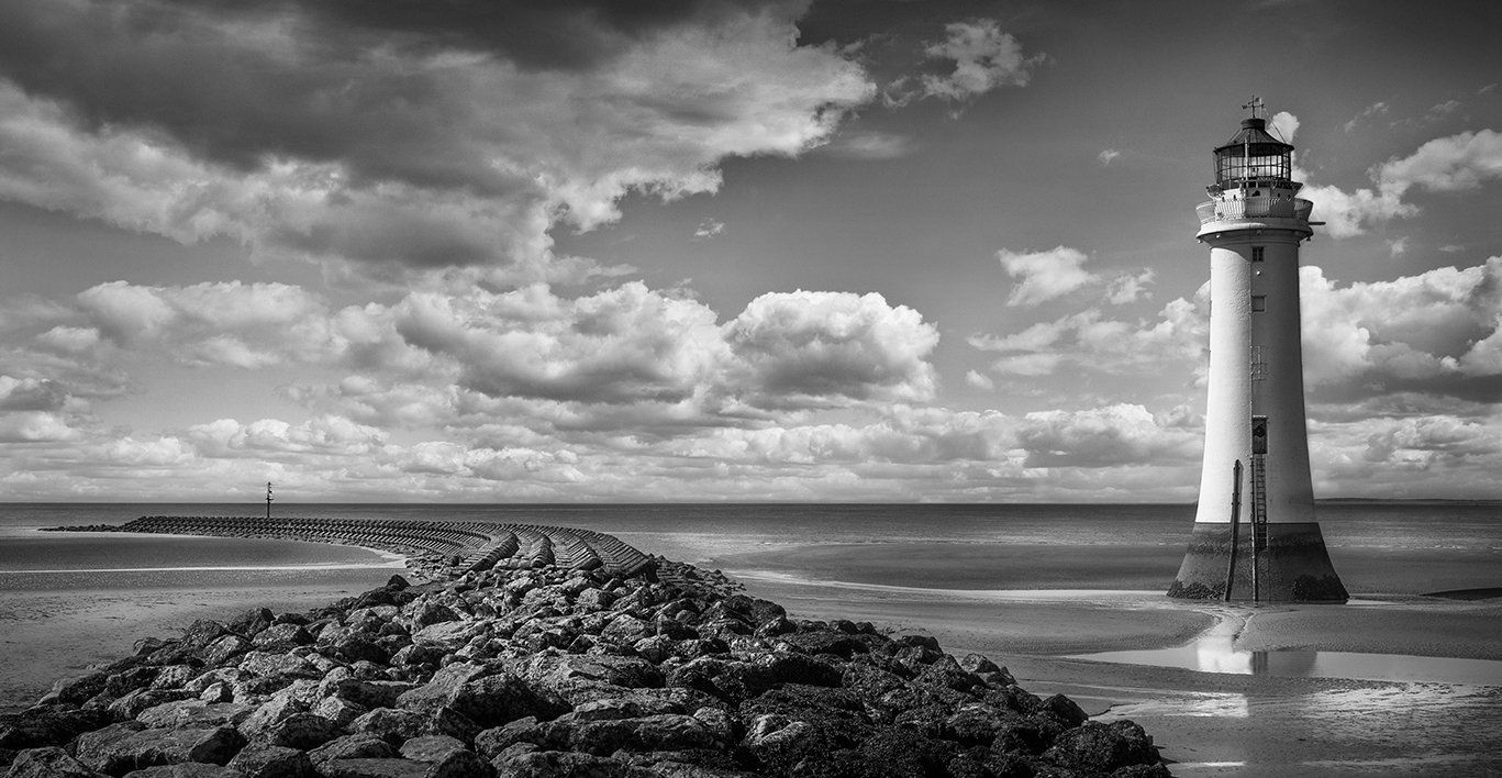 a lighthouse on the rocks from the beach