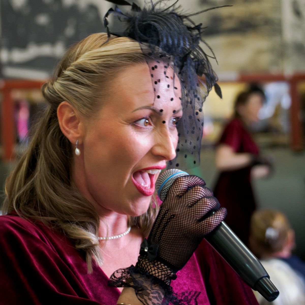 A singer on stage in full vocal flow