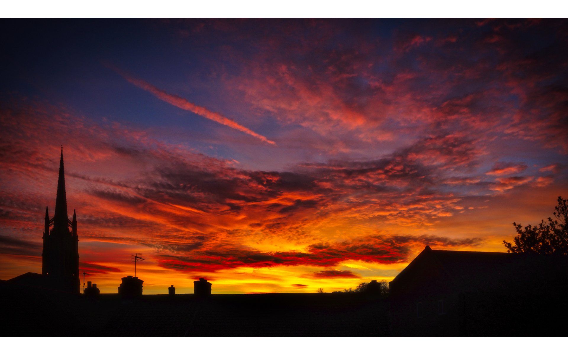 a fiery sunset over rooftops