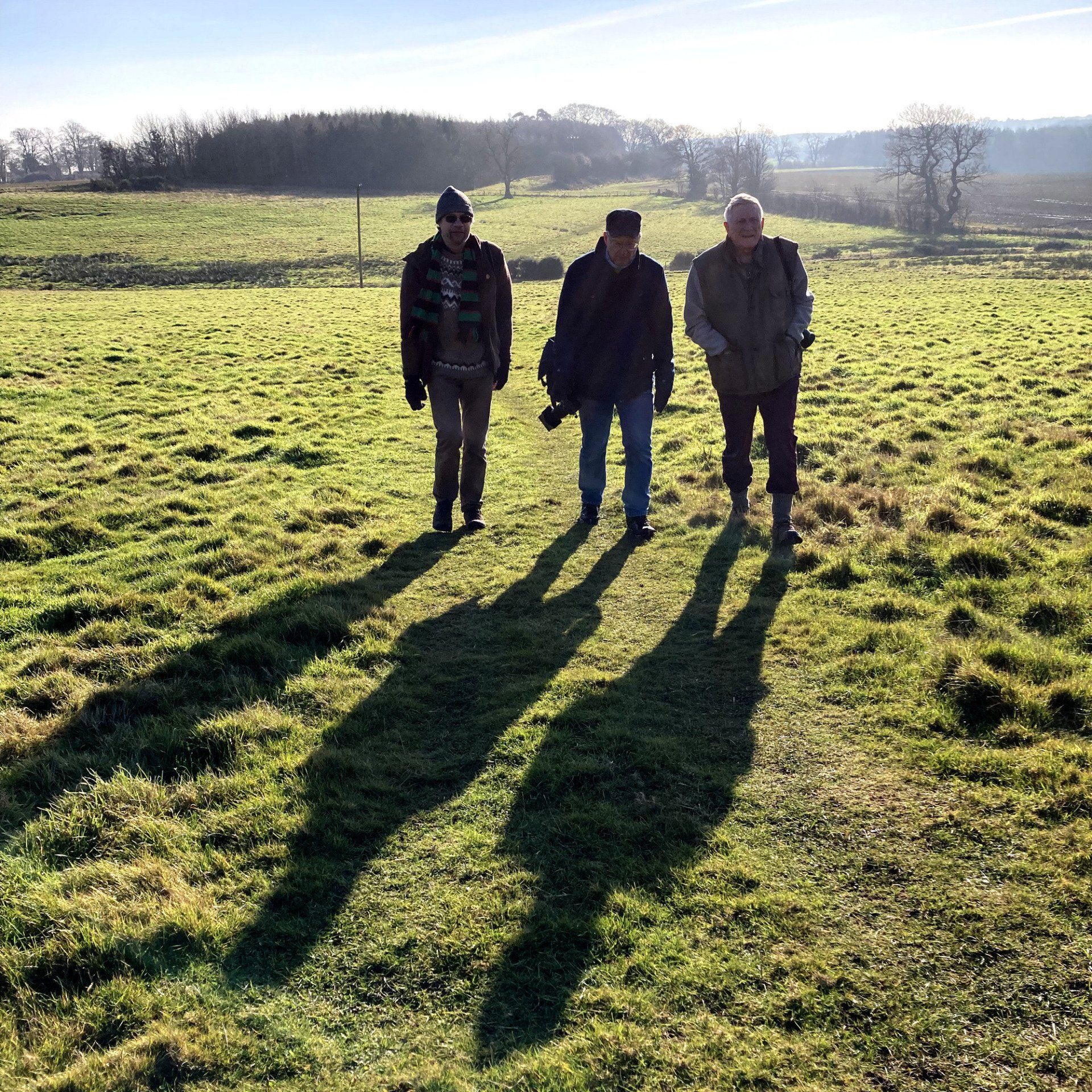 three men walking across a field