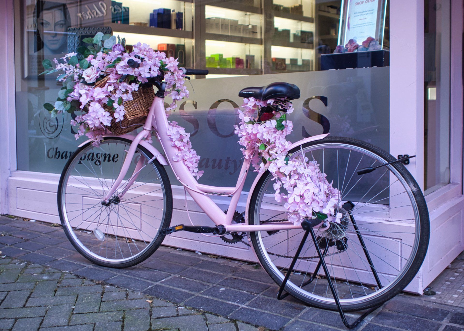 a decorated bicycle outside a hairdressers