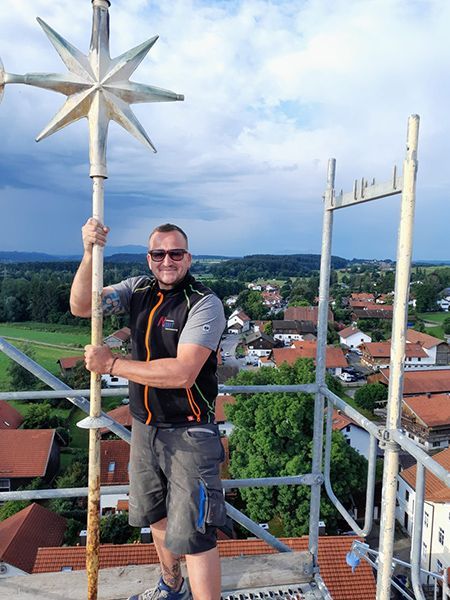 Michael Repert hält den neuen Kirchturmspitzen-Stern von St. Nikolaus