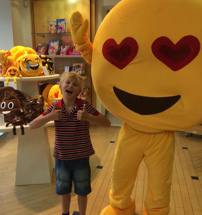 Picture of a young boy with a large Emoji charachter