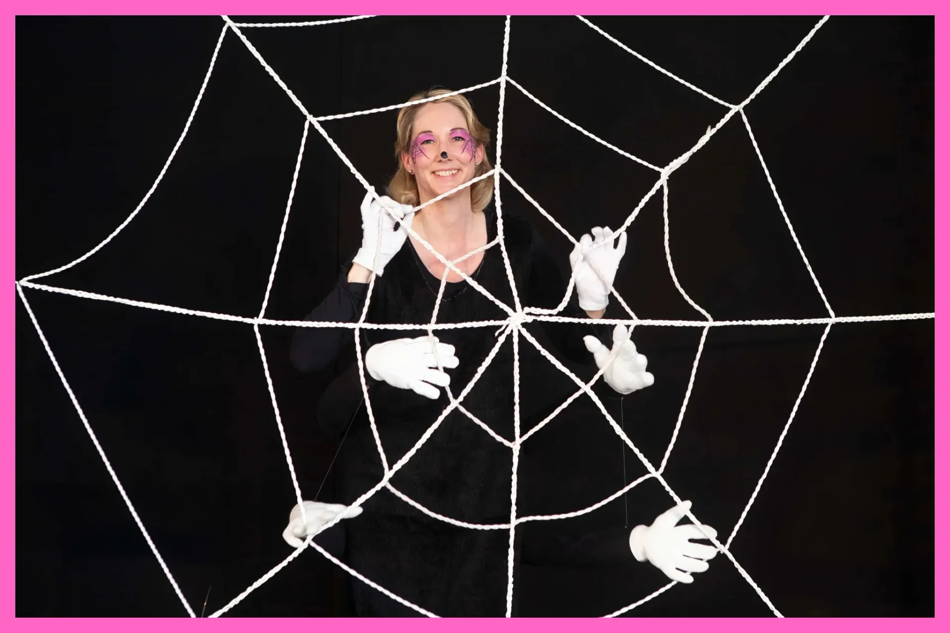 Corine ist als Spinne verkleidet und steht hinter ihrem Spinnennetz.