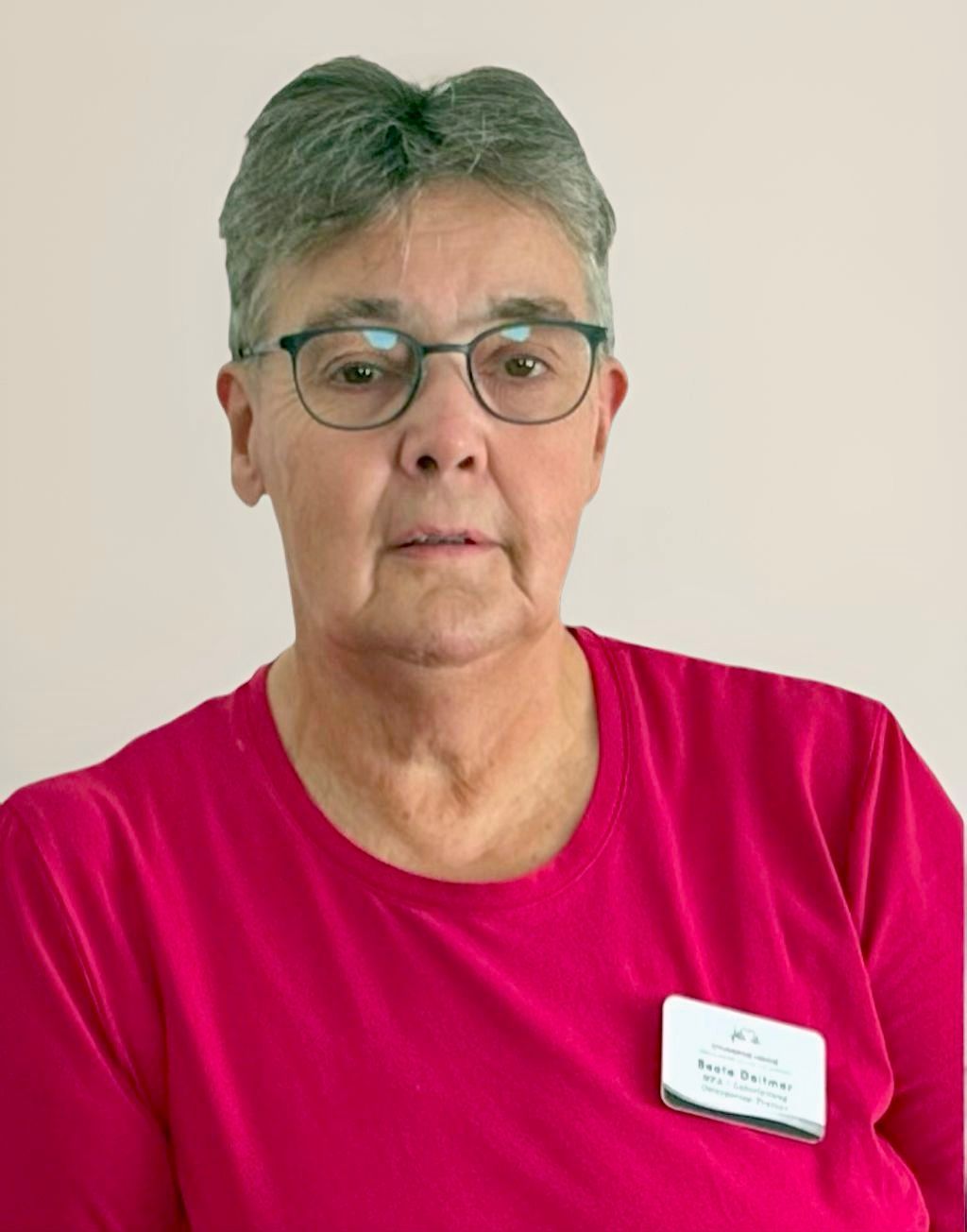 Frau mit kurzen grauen Haaren und Brille