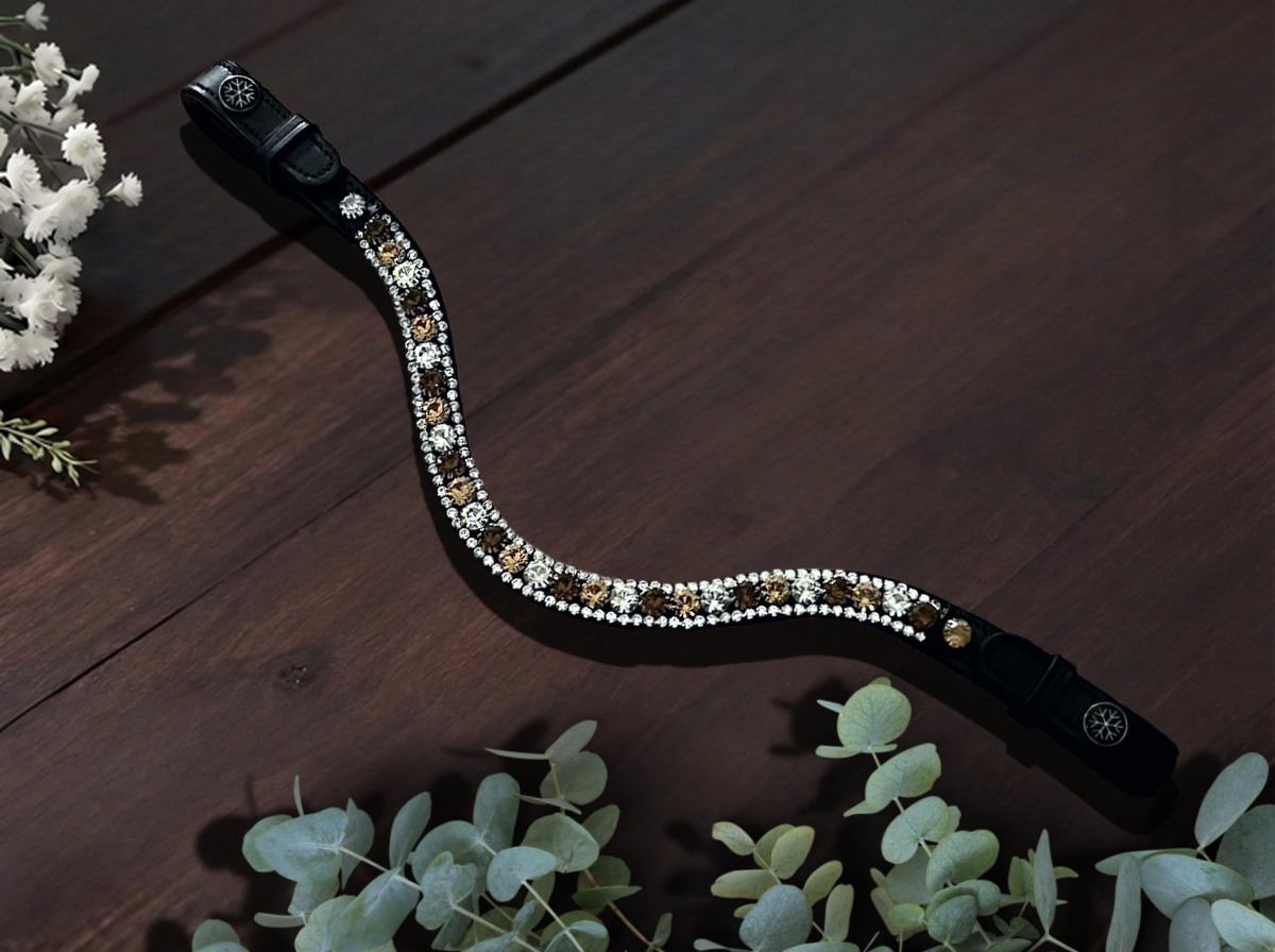 Let every hoofbeat echo with brilliance. Midnight Oasis premium European leather Preciosa crystal browband. Triple-row design with 8mm Preciosa crystals in Smoked Topaz, Light Colorado Topaz and Crystal bordered by 3mm silver crystals. Adjustable quick-change with anti-slip grip. Anatomical deep U-shape fit. All sizes. By Ice Equestrian.