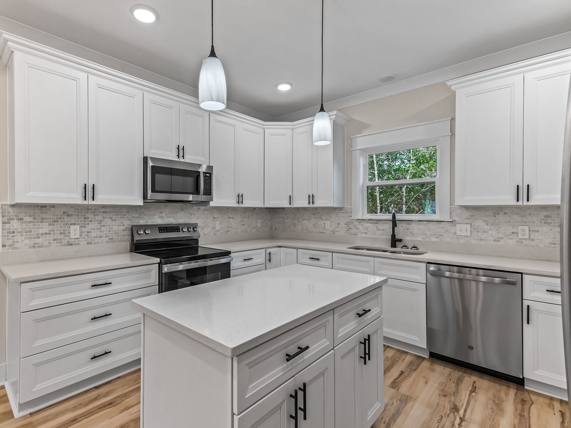 Ibis model kitchen with white shaker cabinets, quartz countertops, and center island – custom home in Crawfordville, FL
