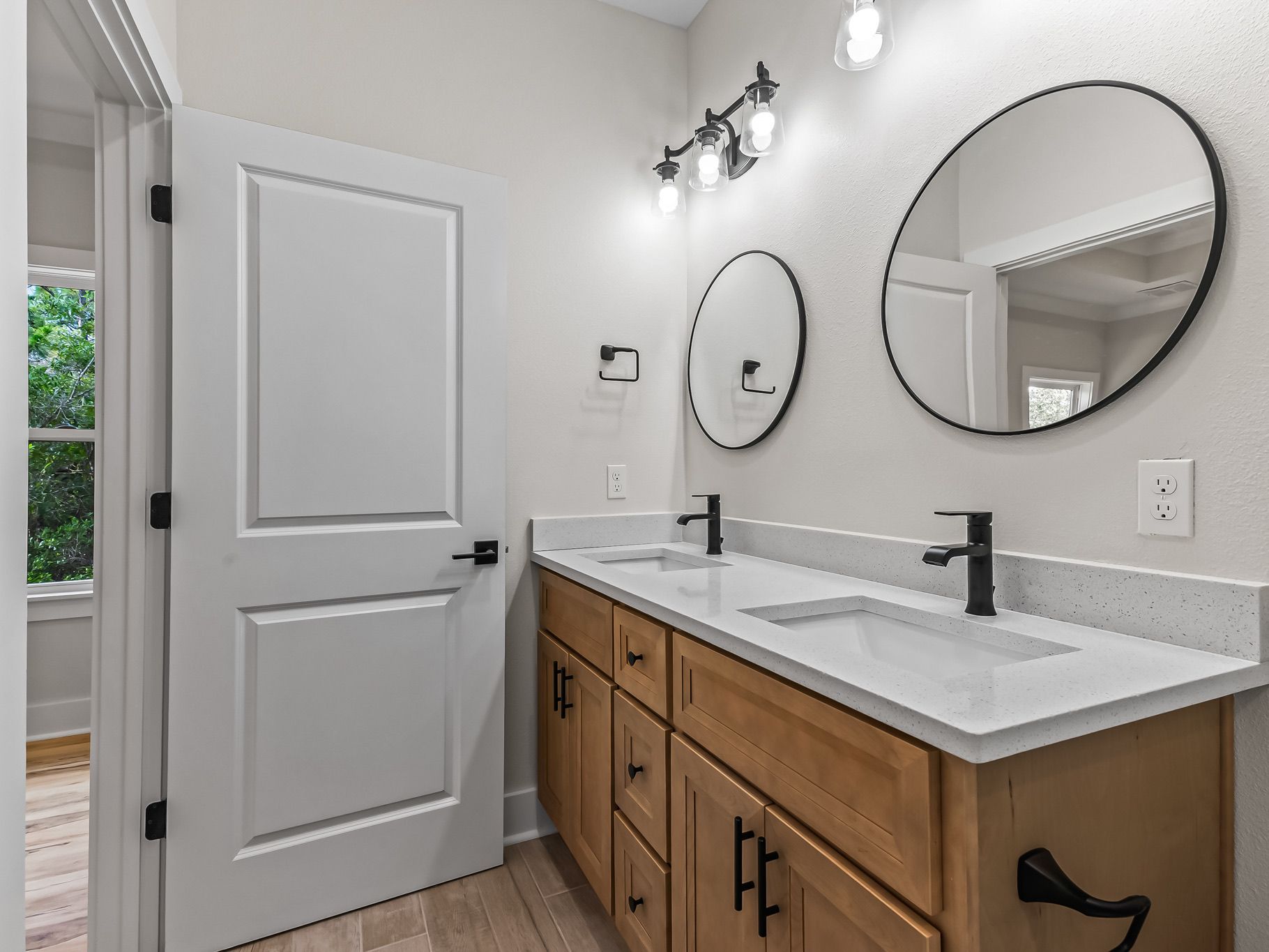 Primary bathroom in Ibis model custom home with wood vanity and matte black fixtures – Crawfordville, FL