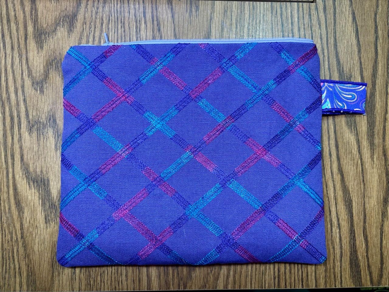 Blue zipper pouch has cover stitch decoration on the back.