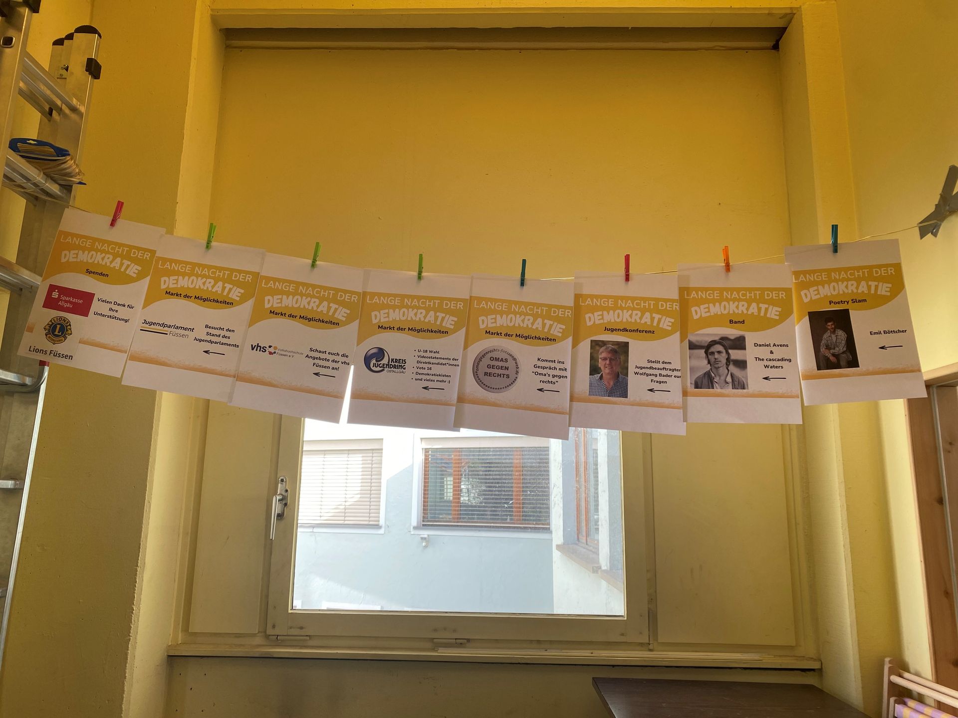 Lange Nacht der Demokratie. Verschiedene Plakate sind an einer Wäscheleine aufgehängt.