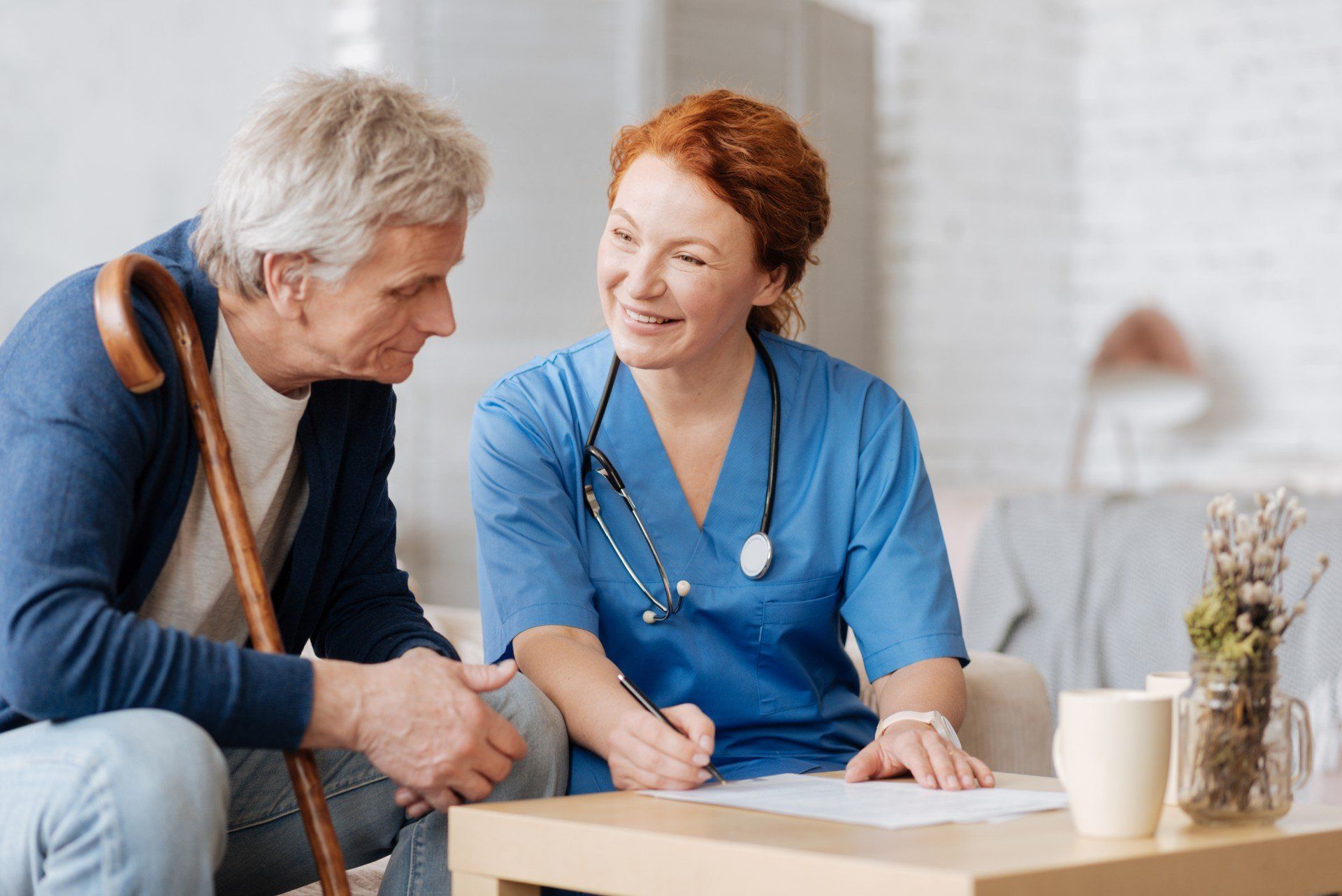 a female nurse going over paperwork with an elderly patient