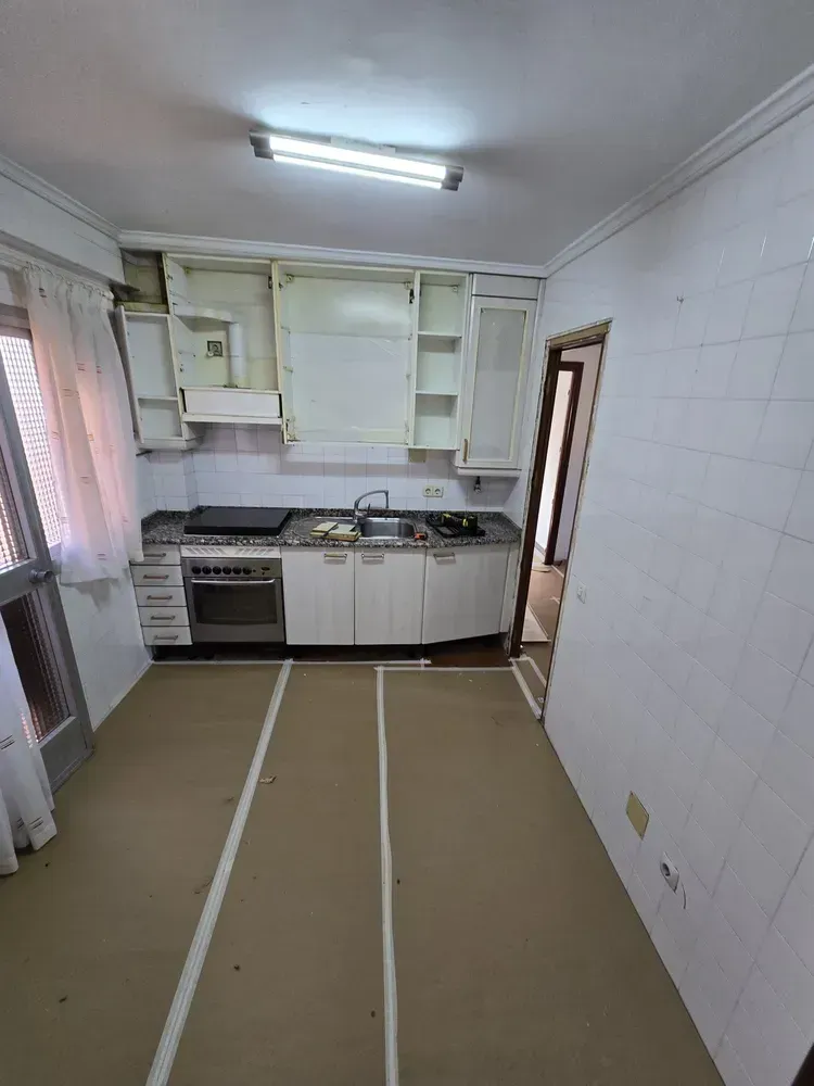 Zona de cocina protegida con cartón técnico y mobiliario desmontado durante reforma en Madrid