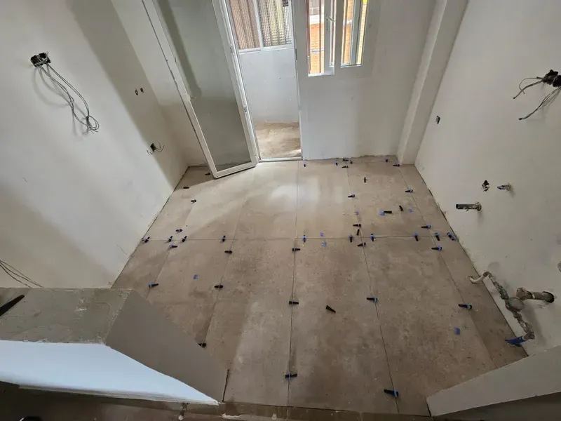 Paredes y suelo de cocina con nueva cerámica durante reforma integral en vivienda de Madrid