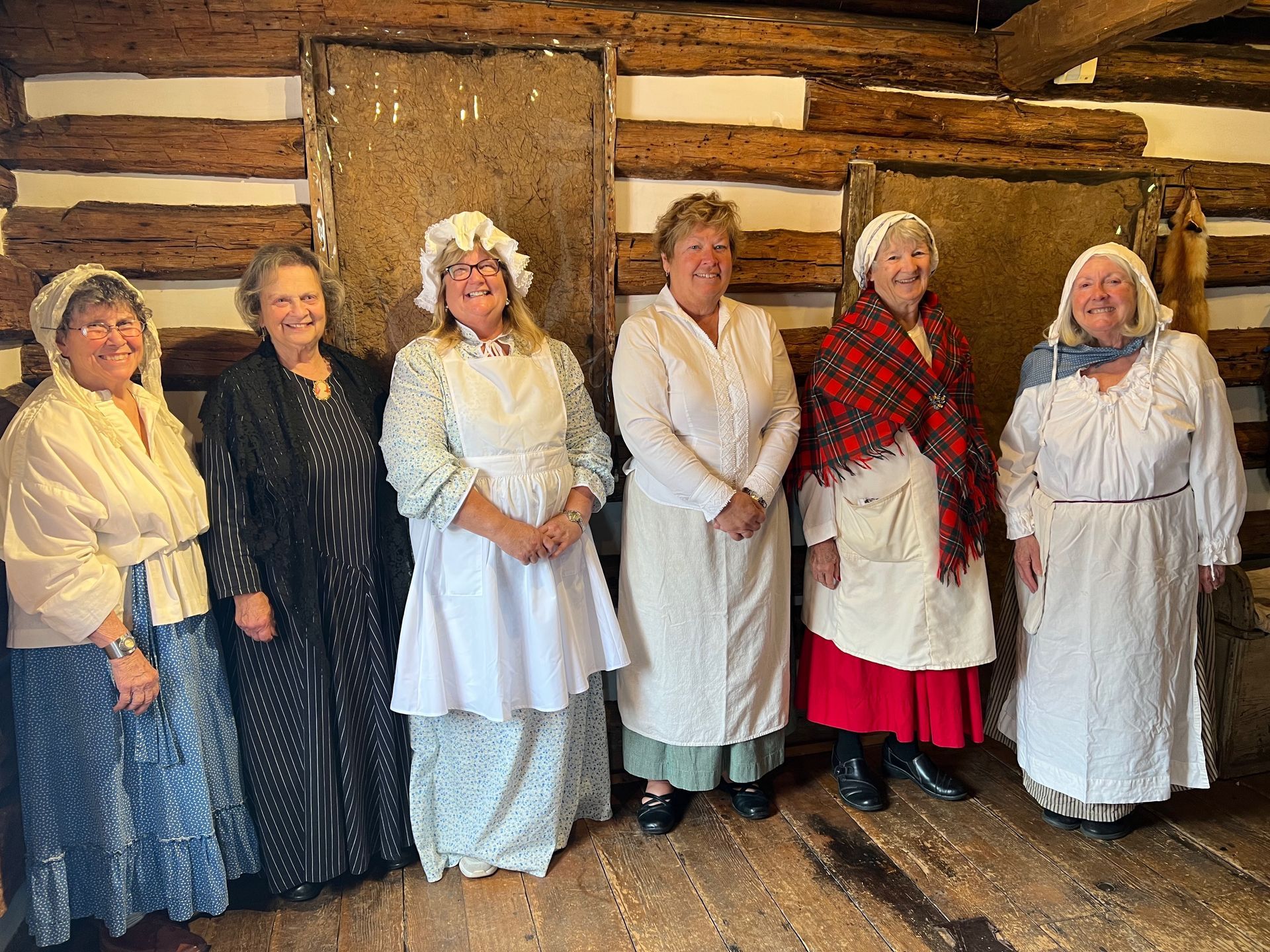 Photo of middle-age to older female volunteer docents dressed in colonial period attire.