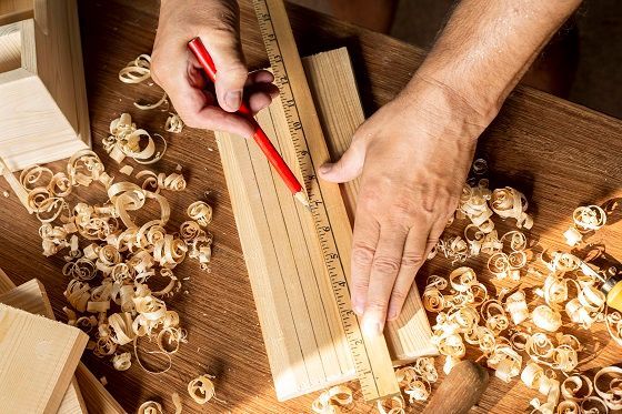 measuring a piece of wood with a ruler