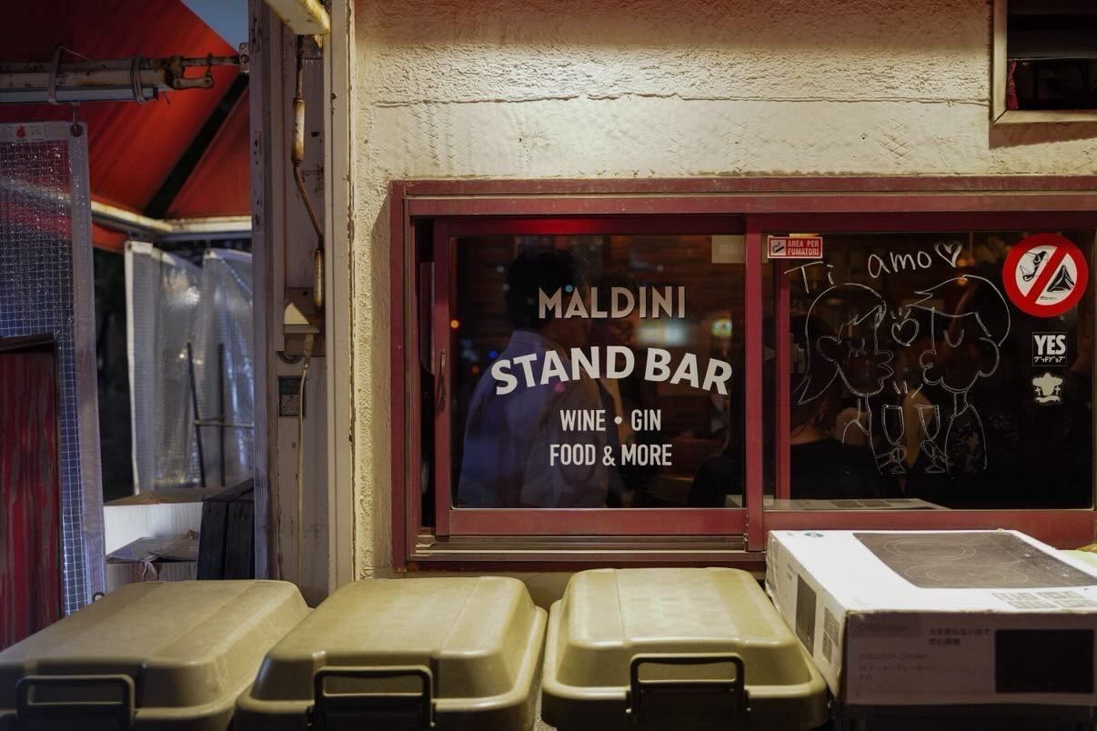 Hand painted signage, logo, and menu items on sliding glass window. White oil based enamel paint. Painted on bar window