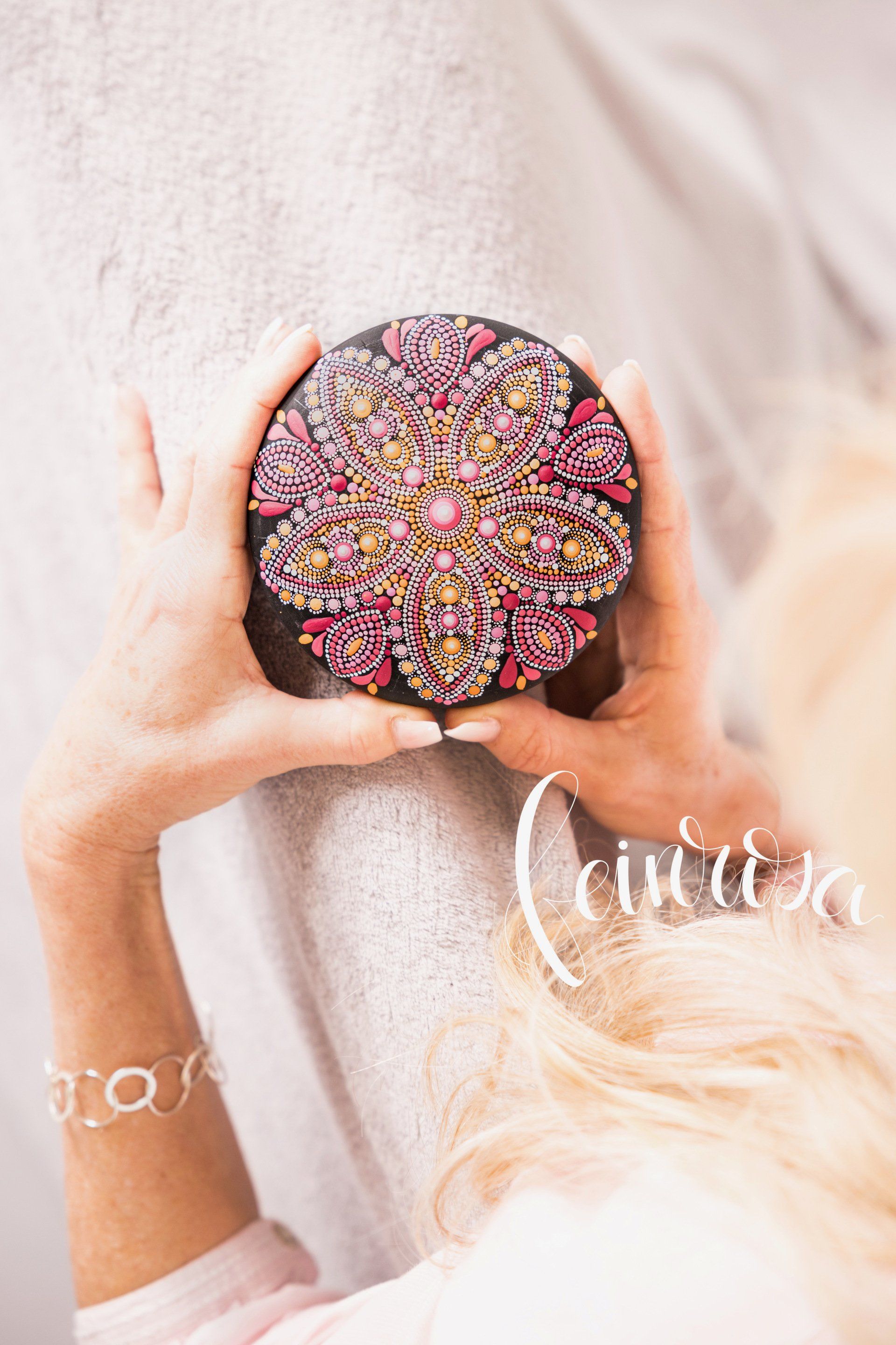 Mandala-Stein Dot-Painting ©Feinrosa, Anja Gries. Handbemalter Mandala-Stein in Pink und Orange-Farbtönen. Symmetrisches Muster zeigt eine Mandala-Blume.