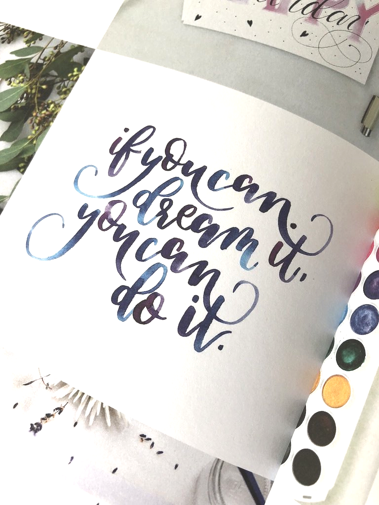 Handlettering in moderner Kalirafie mit Brushpen von Hand gelettert. Die Buchstaben snd farbig und besitzen Farbverläufe von Lila bis Dunkelblau.