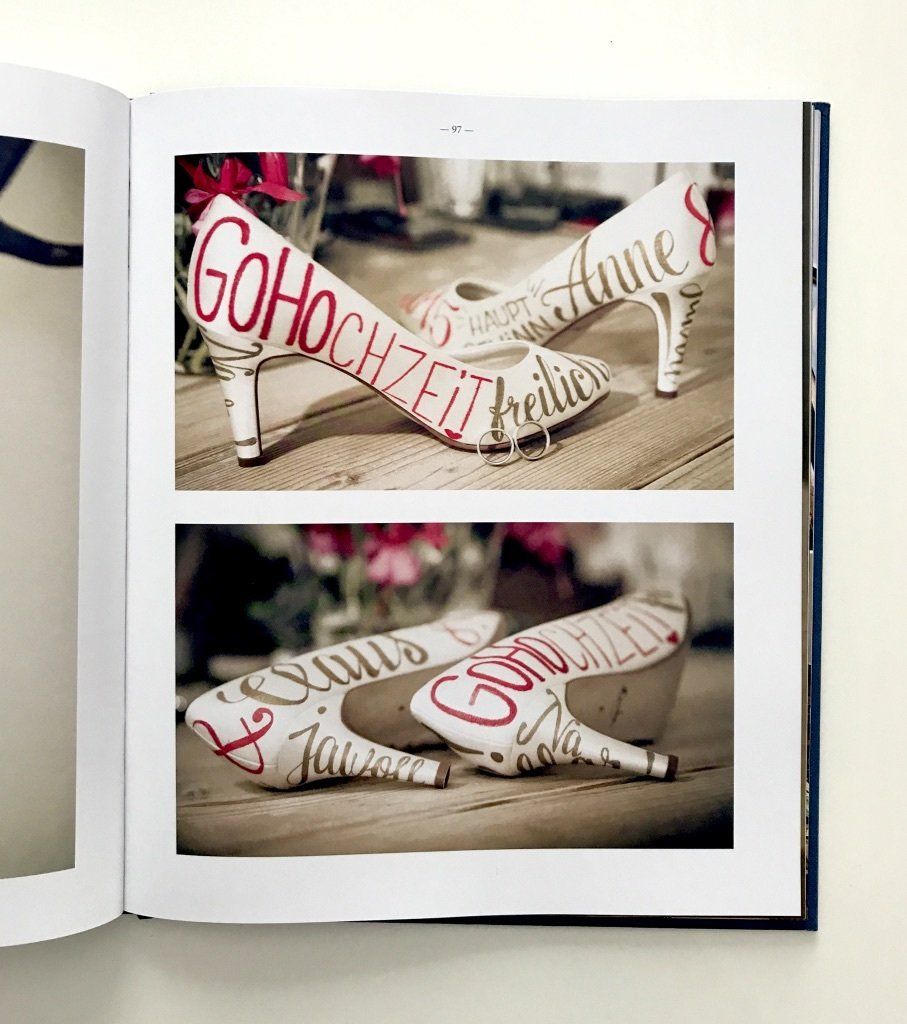 Weiße, hochhackige Schuhe mit Handlettering handbeschriftet.