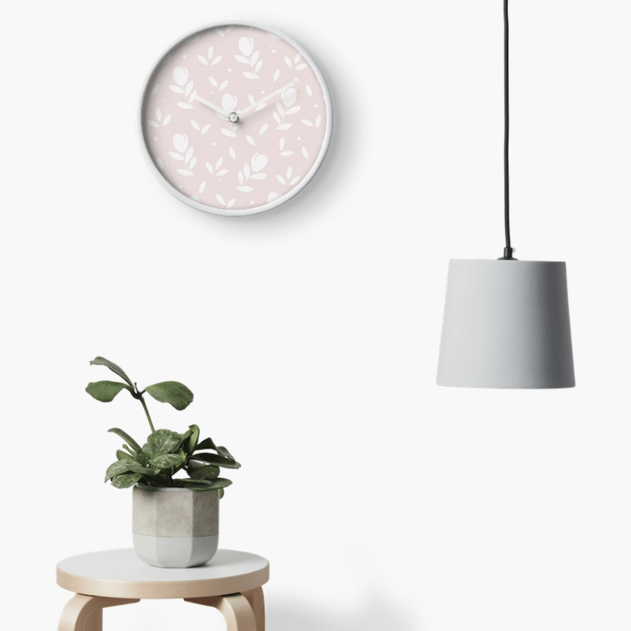 Designer-Uhr mit rosa-weiß-farbenen Blumen-Muster. Design und Produktmuster by Feinrosa. Die Grundfarbe ist ein helles Rosa mit einem weißen Blumen-Muster verziert. Das Produktmuster stellt Tulpen mit zwei Blättern dar. Die Home-Decor-Uhr ist bei Society6 erhältlich.