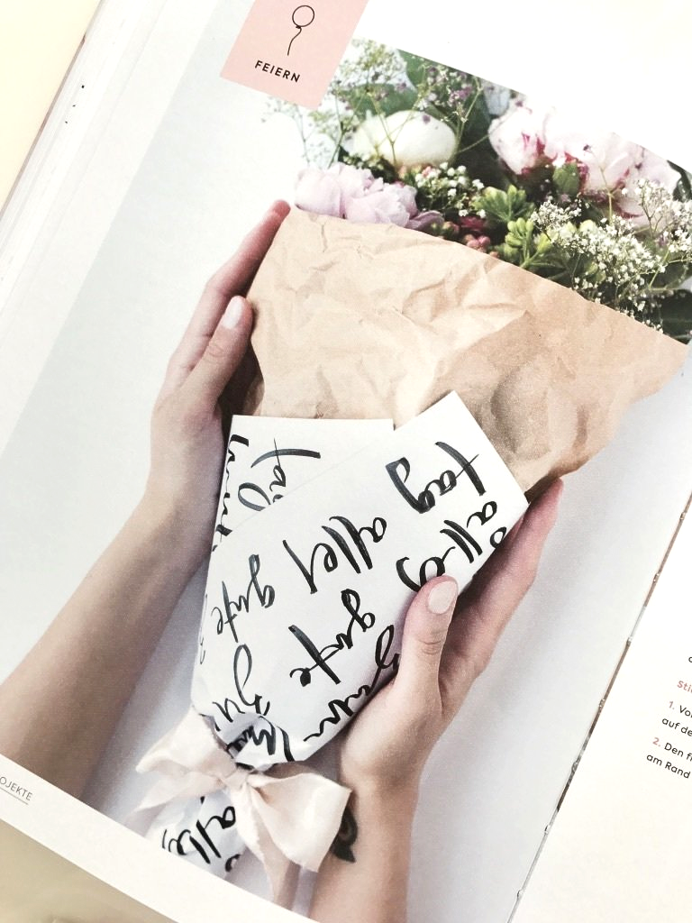 Ein Blumenstrauß mit weißem, beletterten Papier im Handlettering-Stil eingepackt. Die perfekte Geschenkverpackung für Blumensträuße.