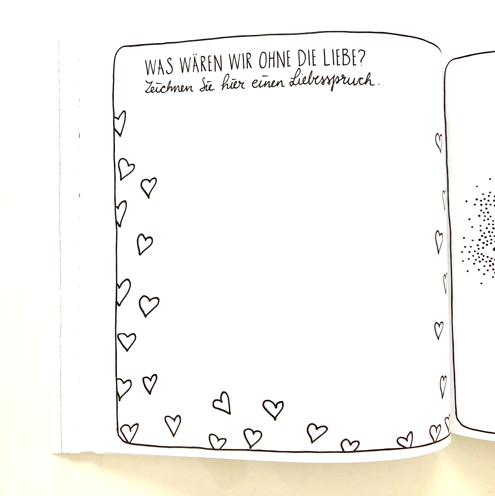 Buchseite die auffordert einen Spruch über Liebe zu lettern. Die Seite ist umrahmt mit vielen schwarzen Herzen.