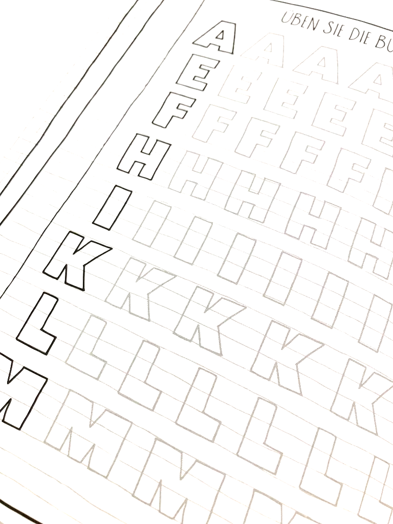 Handlettering lernen Übungsseite im Buch. Eine Reihe schwarzer Großbuchstaben dienen der Vorlage. Die gleichen Buchstaben, sich mehrfach wiederholend in grau, sollen vom Handlettering-Anfänger überschrieben werden.