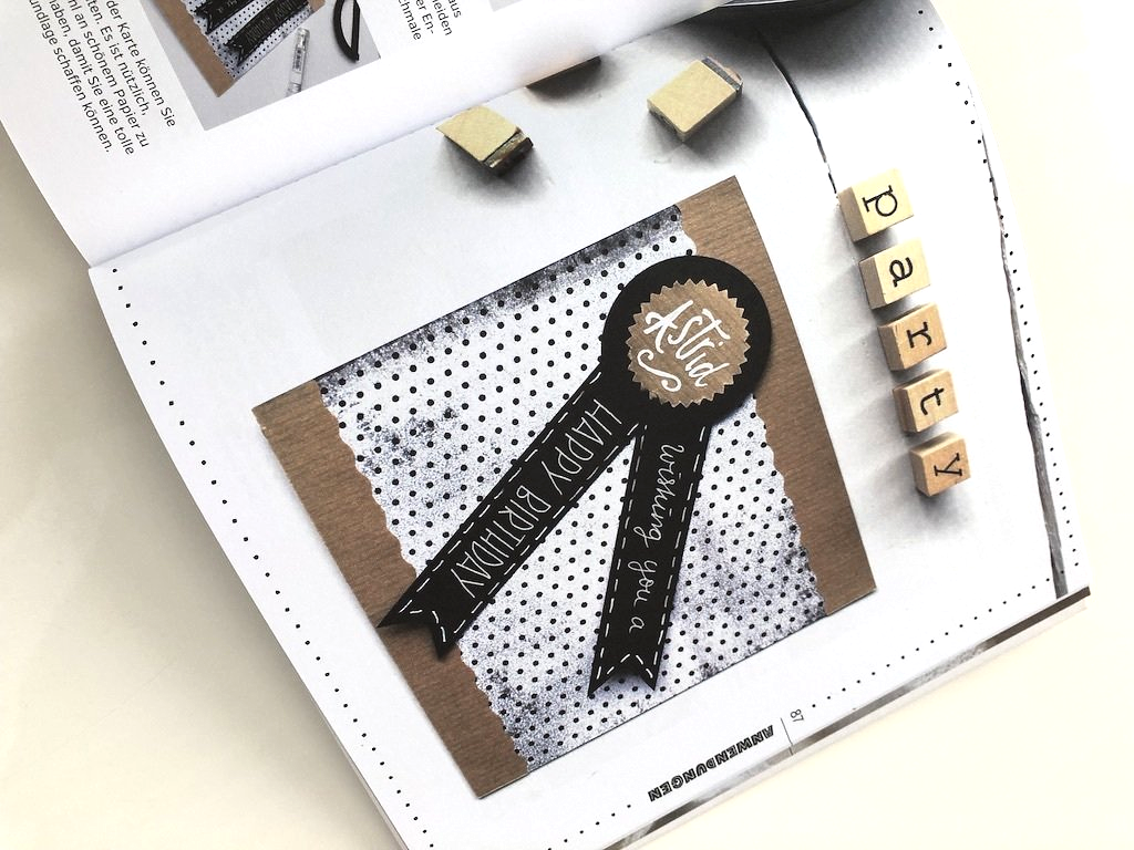 DIY-Geburtstagskarte aus Kraftpapier. Handgebastelter Wimpel aus schwarzem Papier mit weißem Handletting