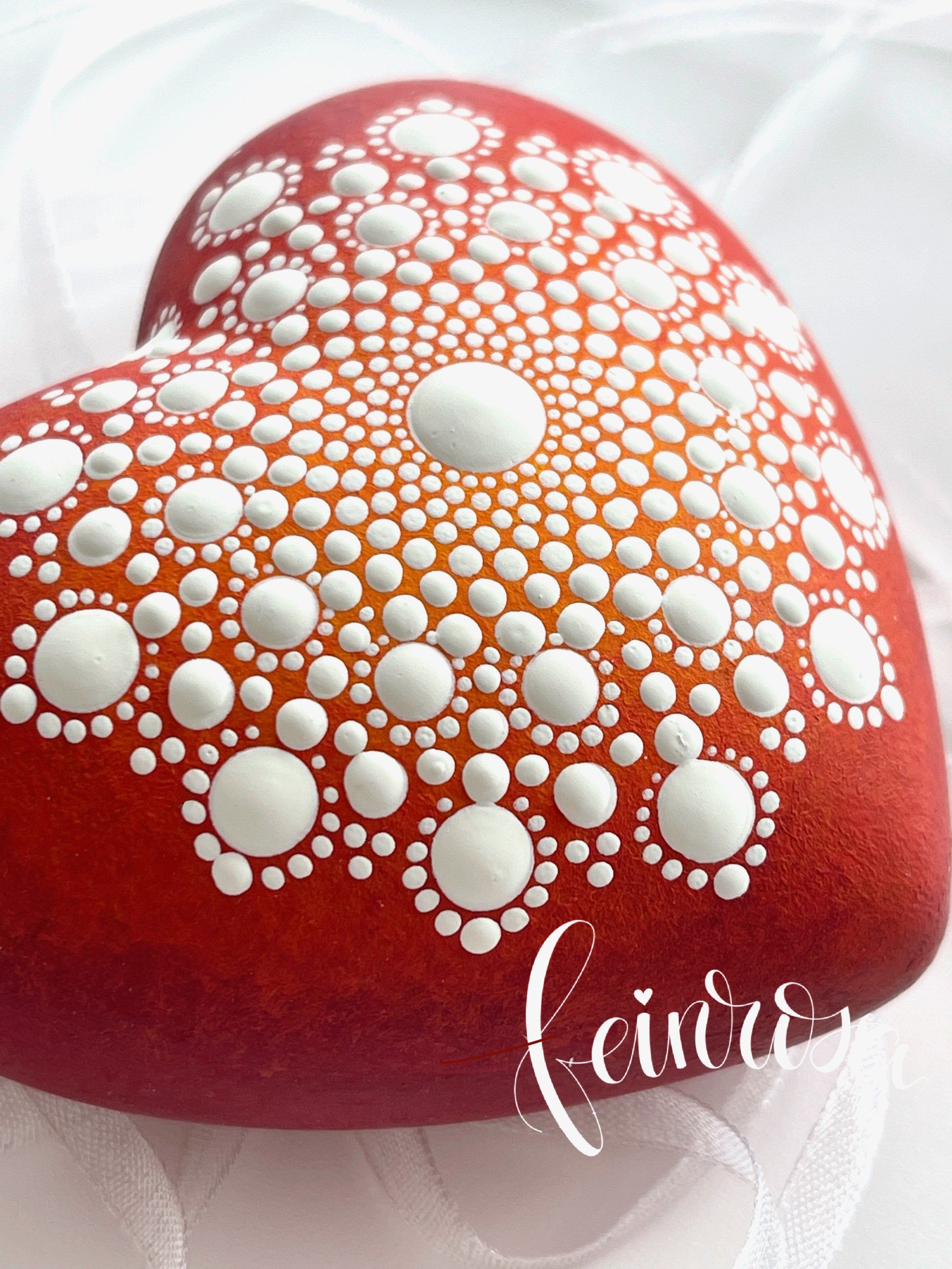 Mandala-Herz aus Gips. Bemalt mit einem rot-gelben Farbverlauf als Grundierung. Darauf ist ein weißes Mandala-Muster gemalt. Die Dot-Painting Maltechnik, Punktmalerei mit Dotting-Tools.