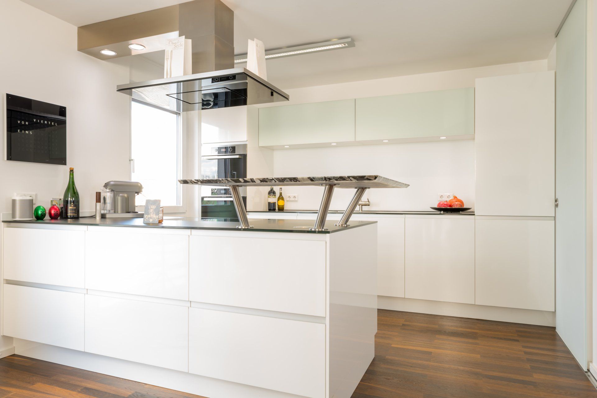 Weiße Kücheninsel mit Barplatte/kleinem Tresen aus Granit und eleganter Abzugshaube