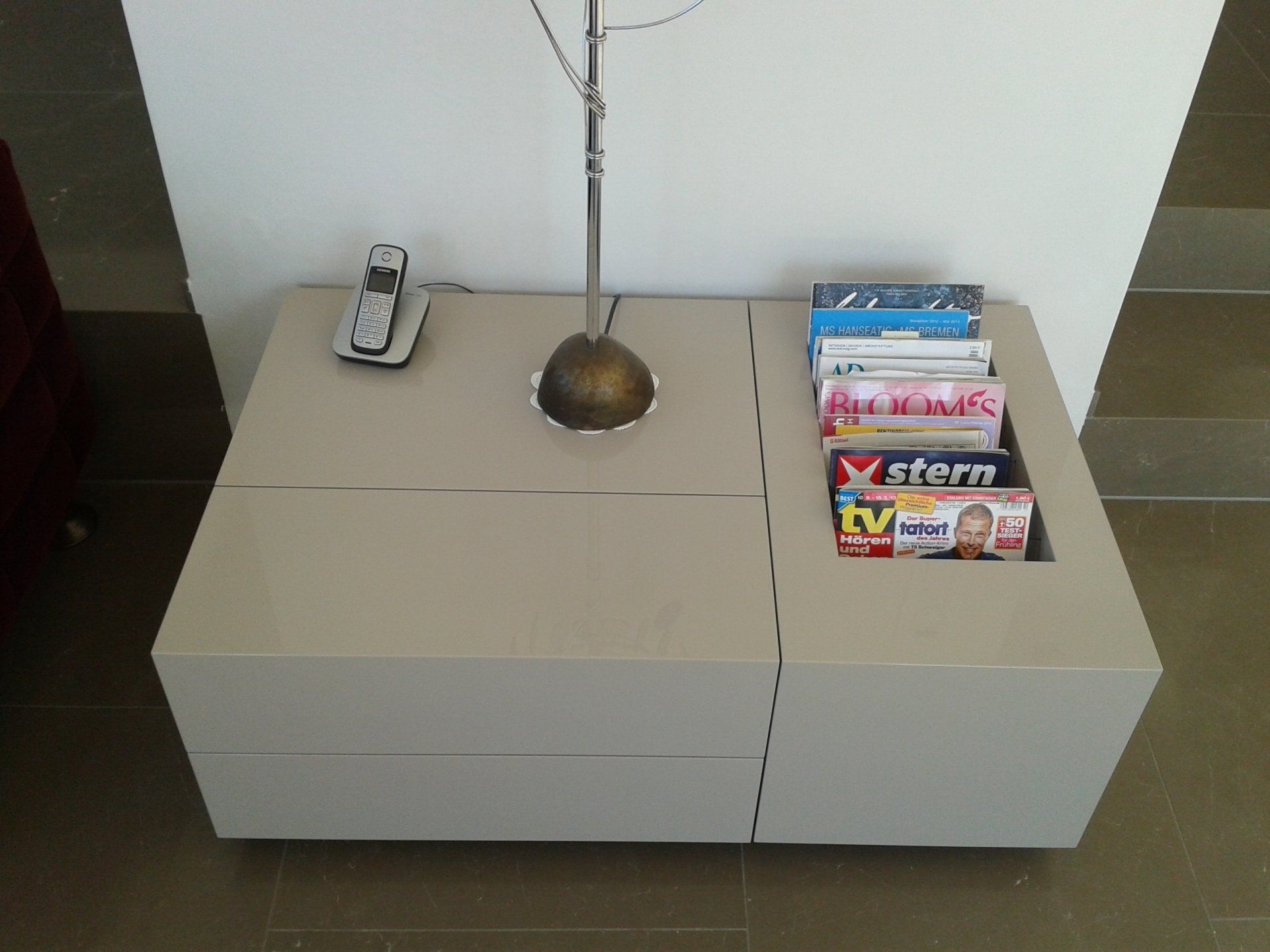 Ein modernes Wohnzimmer-Lowboard mit grifflosen Fronten, Fächern für Zeitschriften, Deko