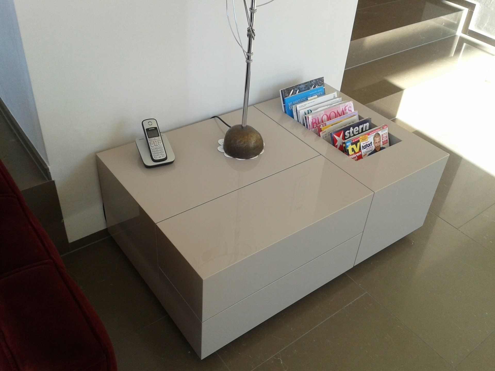 Ein modernes Lowboard mit grifflosen Fronten und Fächern für Zeitschriften