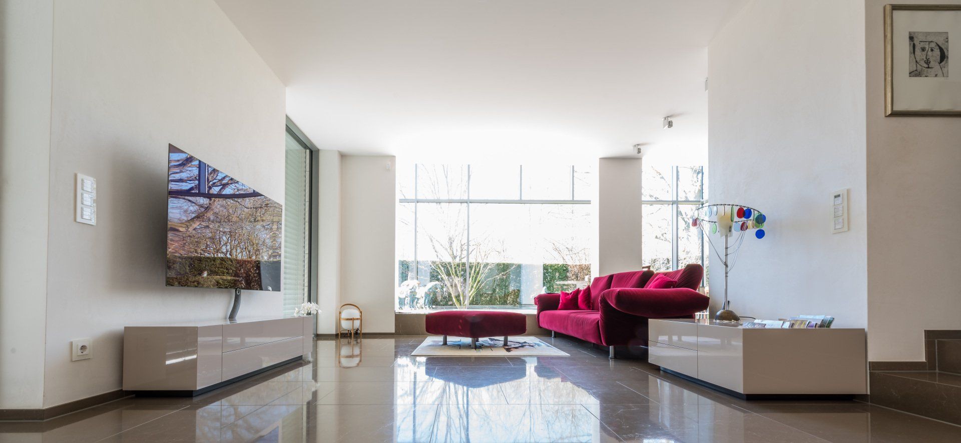 Wohnzimmer mit zwei Hochglanz-Möbeln der Schreinerei BLEIER Lebensräume: TV-Lowboard, Lowboard, Sofa, Marmorfussboden