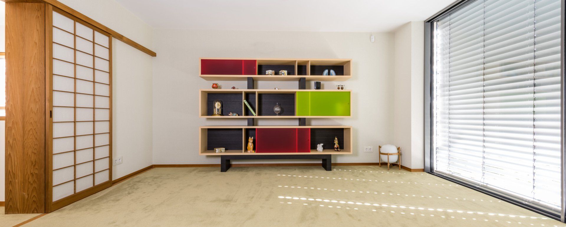 Leichtbau-Regal von Schreinerei BLEIER Lebensräume, mit satinierten Acrylglasfronten in Grün und Rot, sehr edel in einem hellen Raum