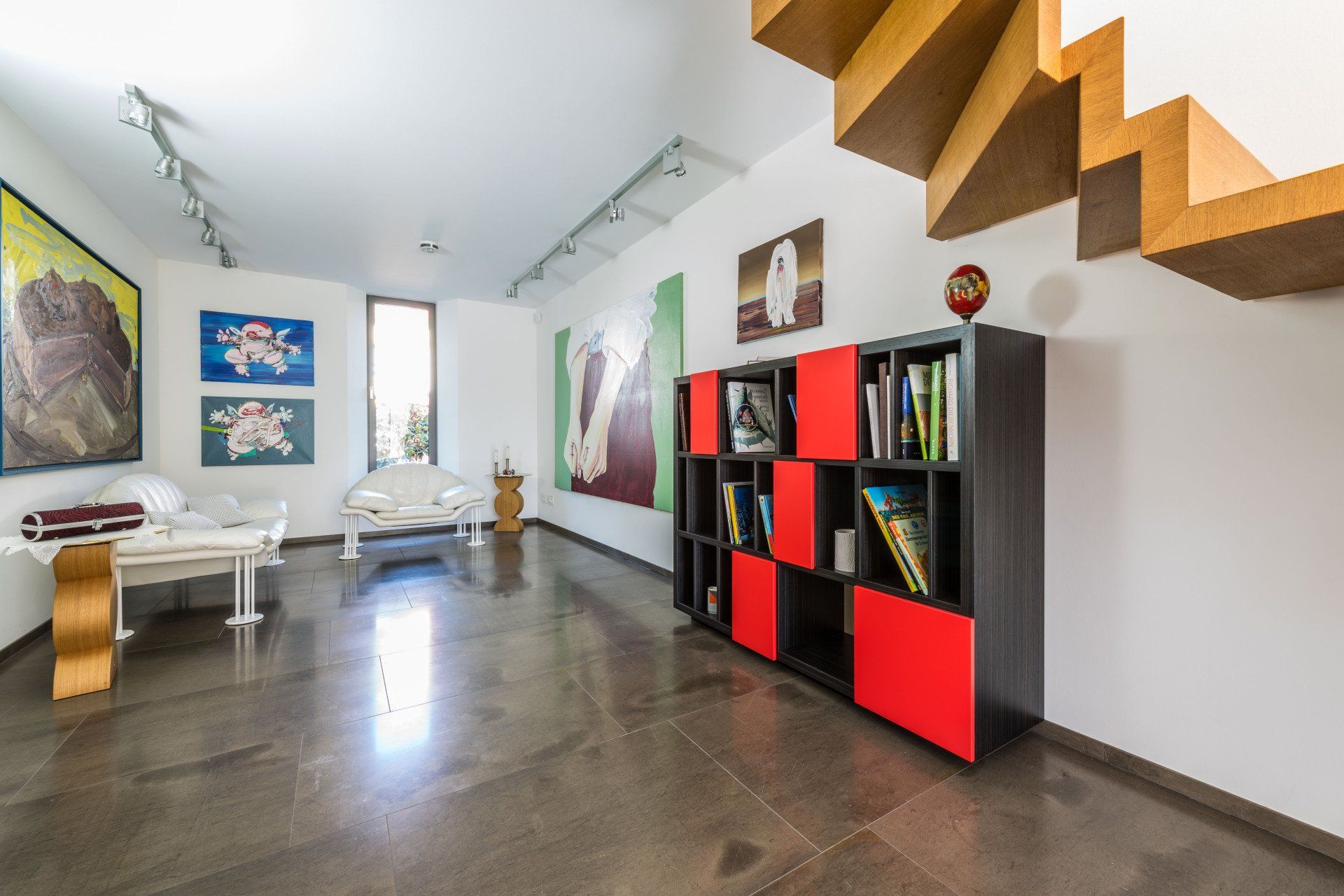 Das rot-schwarze Ebenholz-Regal von Schreinerei Bleier (Raum Karlsruhe) im Raum, sehr edles Ambiente mit Luxus-Möbeln und Kunstgegenständen