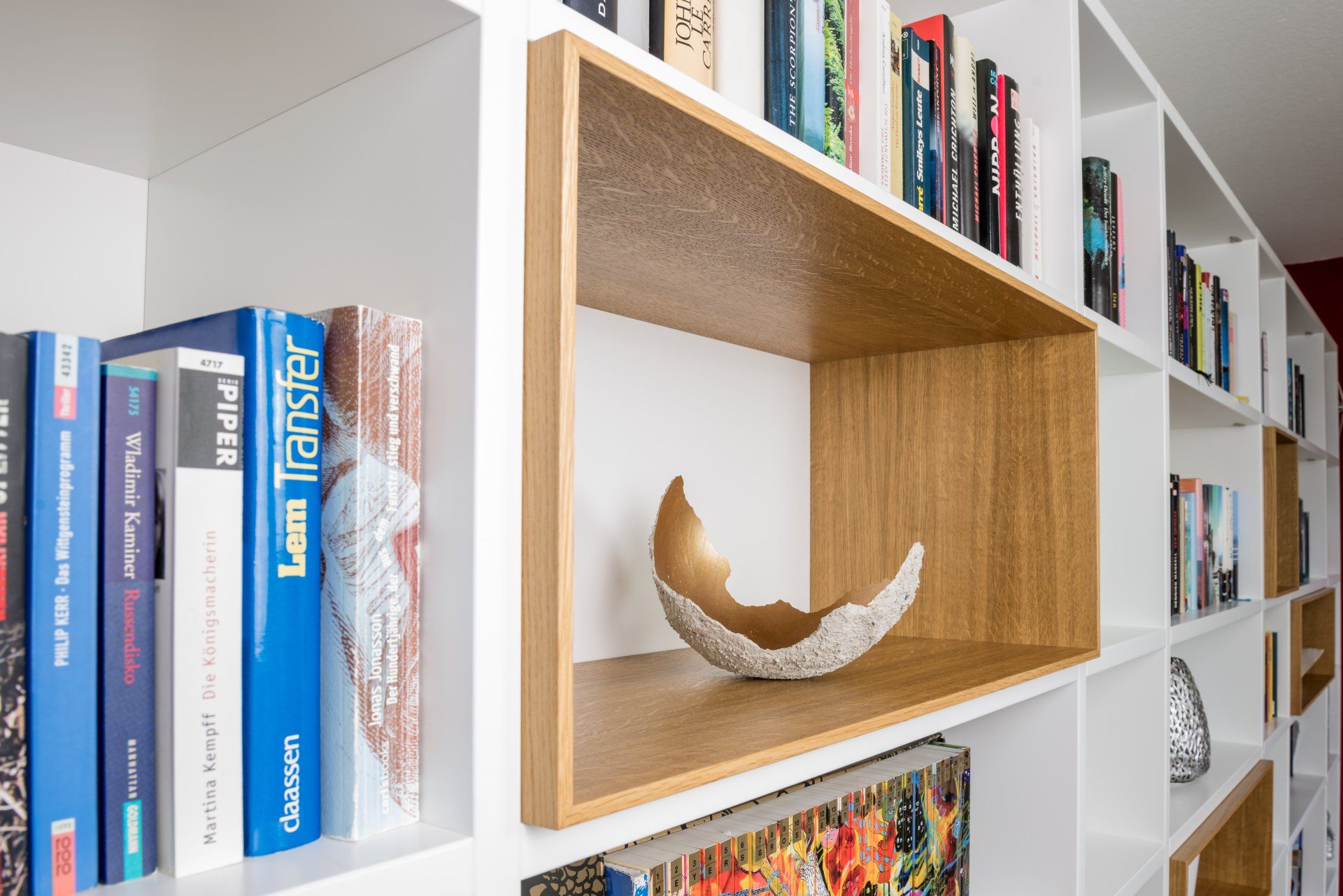 Bücherwand mit Einschub aus edlem Holz und mit Deko