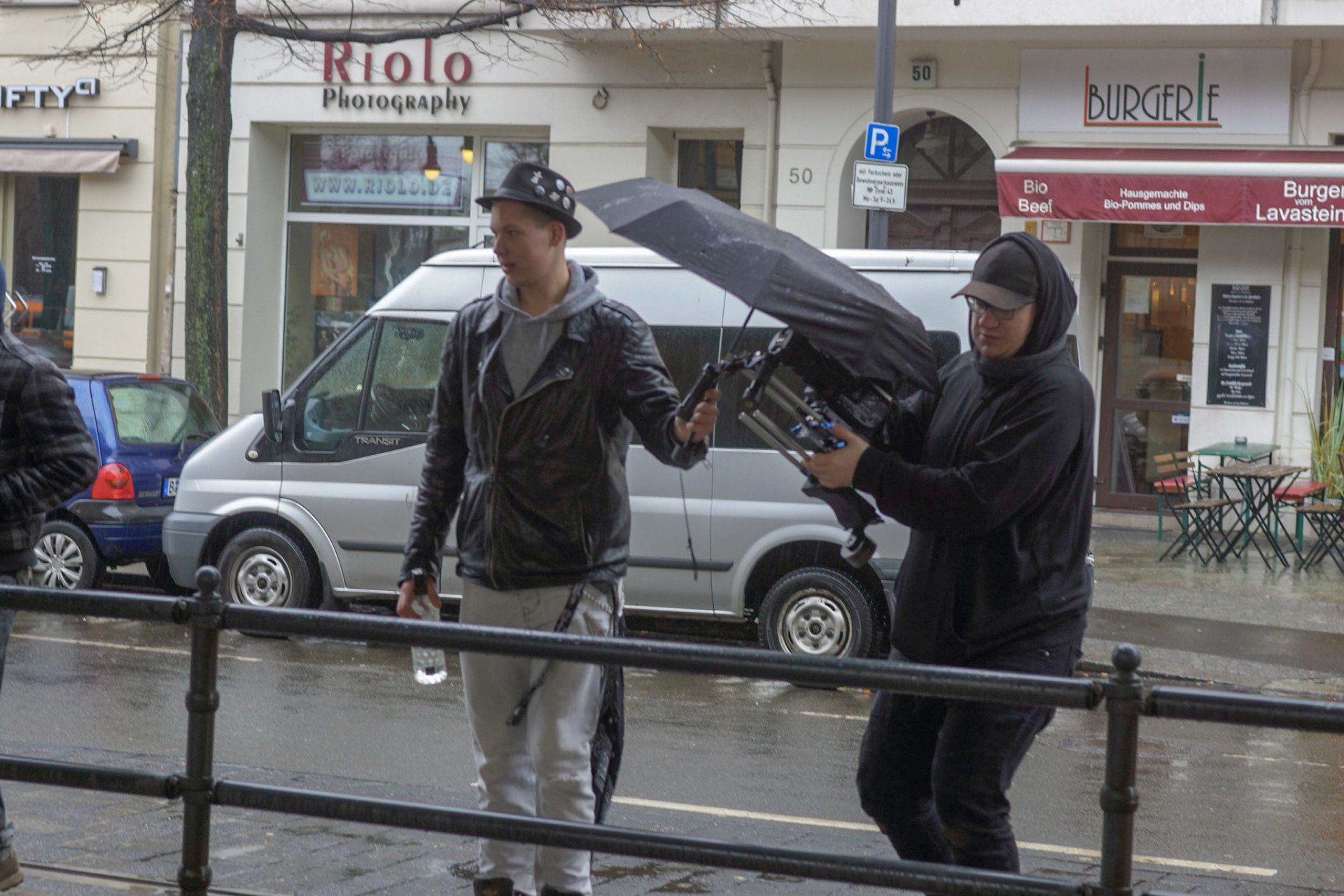 Tobijan Torrentino schützt die Filmkamera von Caspar Dudek mit einem Regenschirm. Jevatta beim Videodreh zum Song: