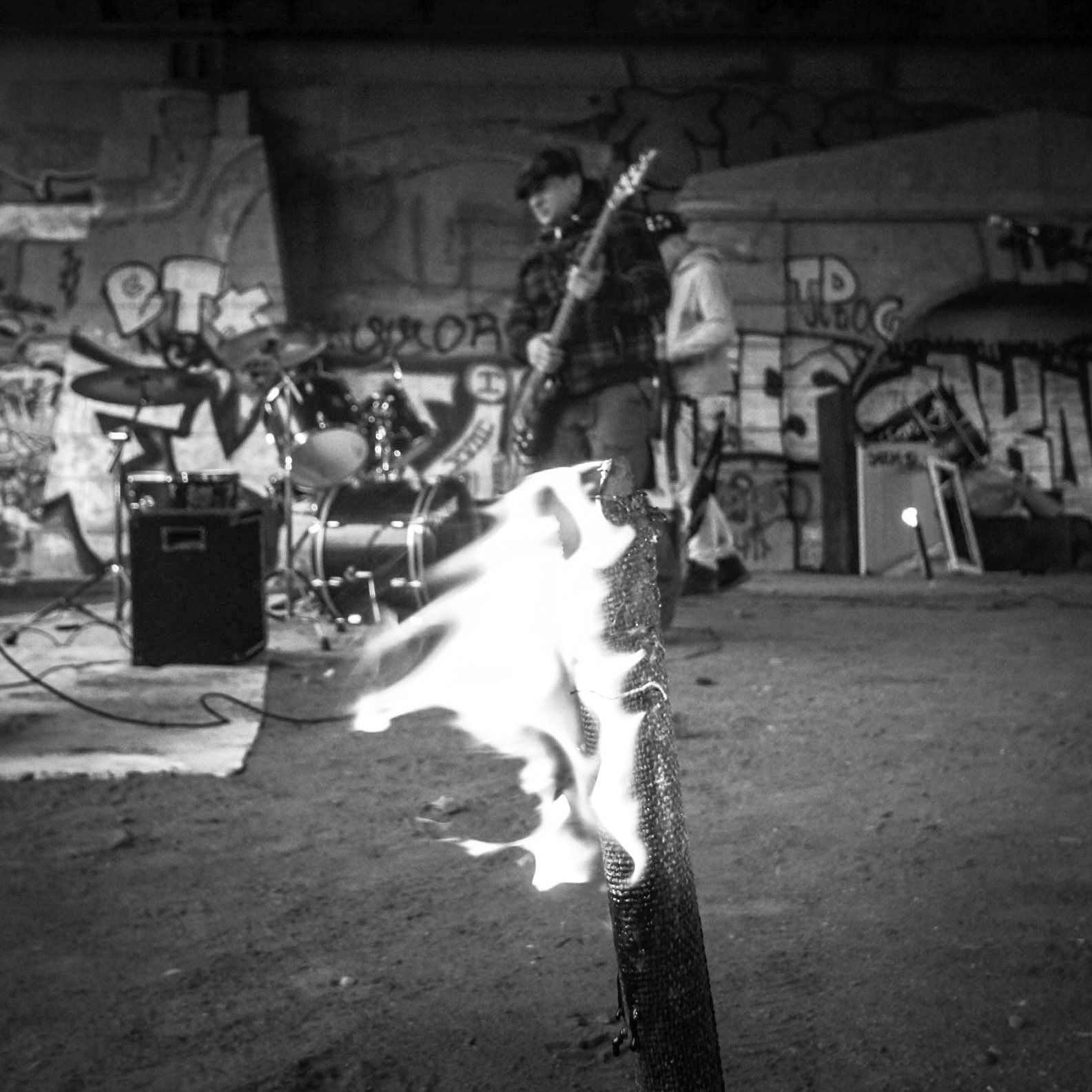 Indi Pahn trifft Vorbereitungen mit seinem E-Bass und Tobijan Torrentino bereitet sich mit seiner E-Gitarre vor. Die Fackeln brennen. Jevatta beim Videodreh.