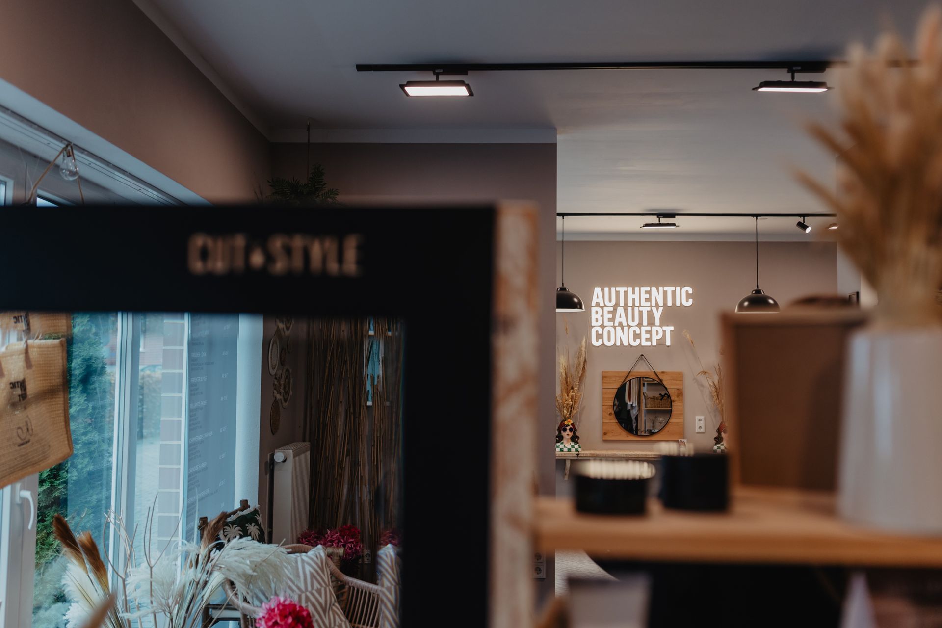 „Innenansicht des Friseursalons Cut and Style Bielefeld mit Spiegel und Salondeko im Vordergrund