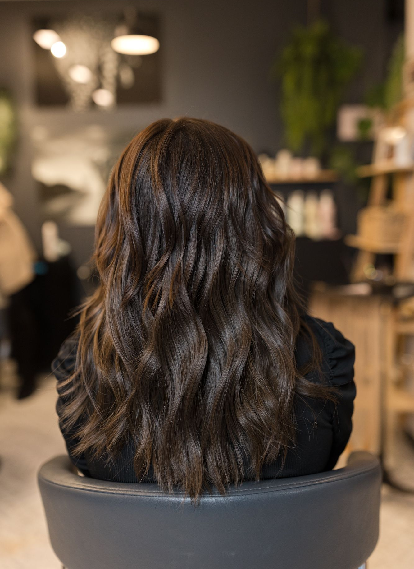 Vorher-Nachher-Vergleich einer Haarverdichtung: dunkles Haar von schulterlang zu vollerem, längeren Haar.
