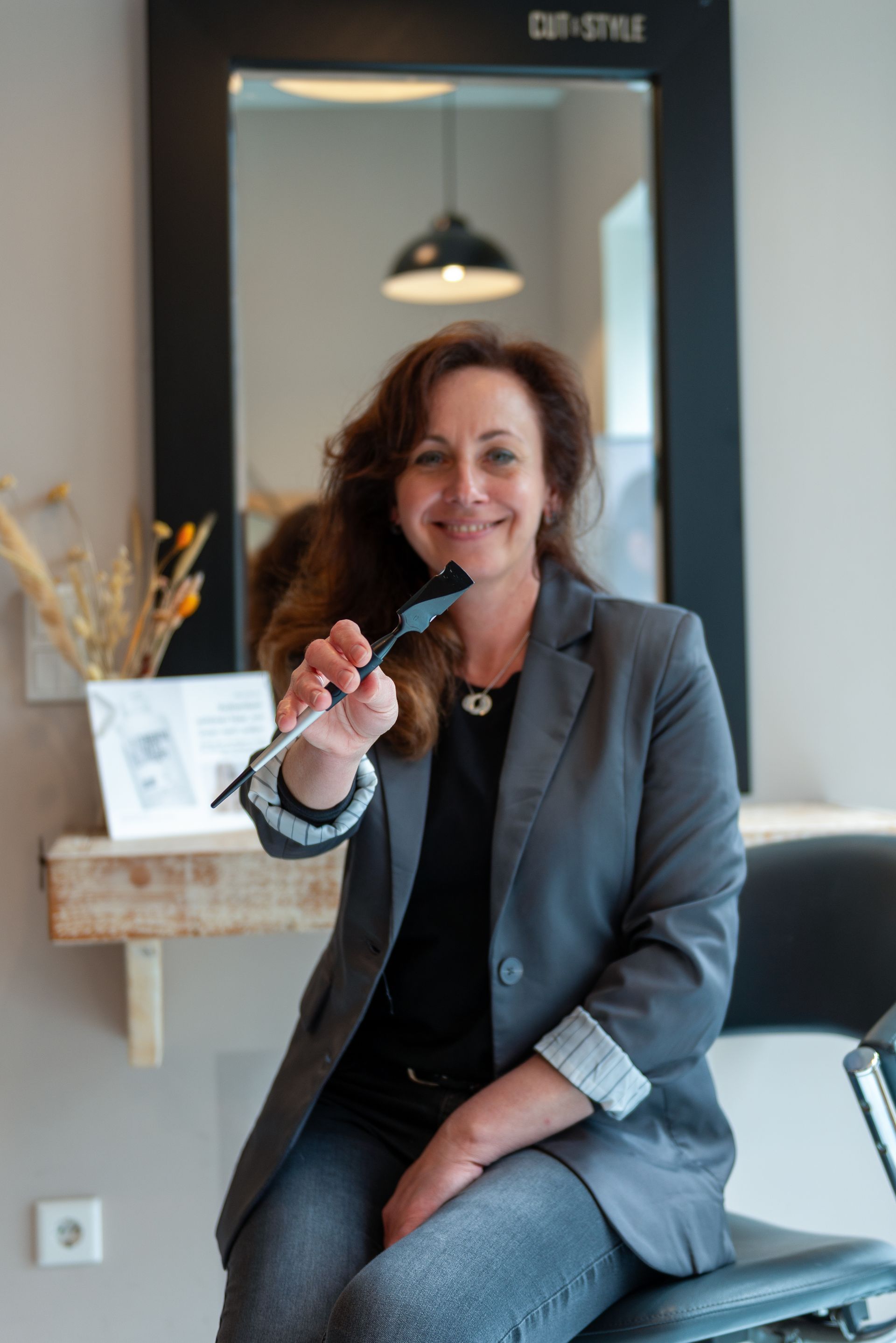 Tatjana, Professional Stylist bei Cut and Style Bielefeld, hält Calligraphy-Messer im Arbeitsbereich