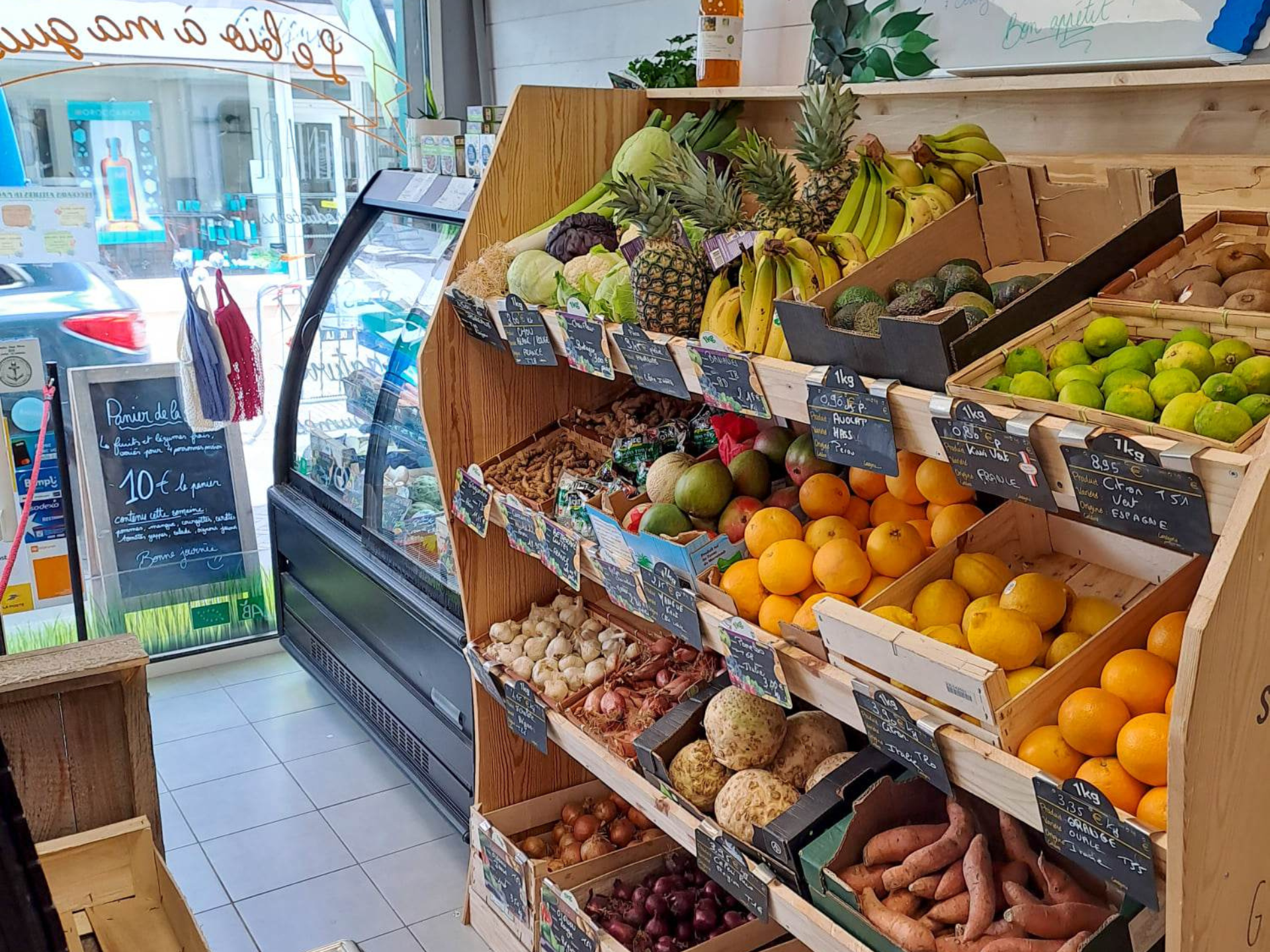 Photo du rayon de fruits et légumes, montrant des oranges, des citrons, des pommes, des choux etc.