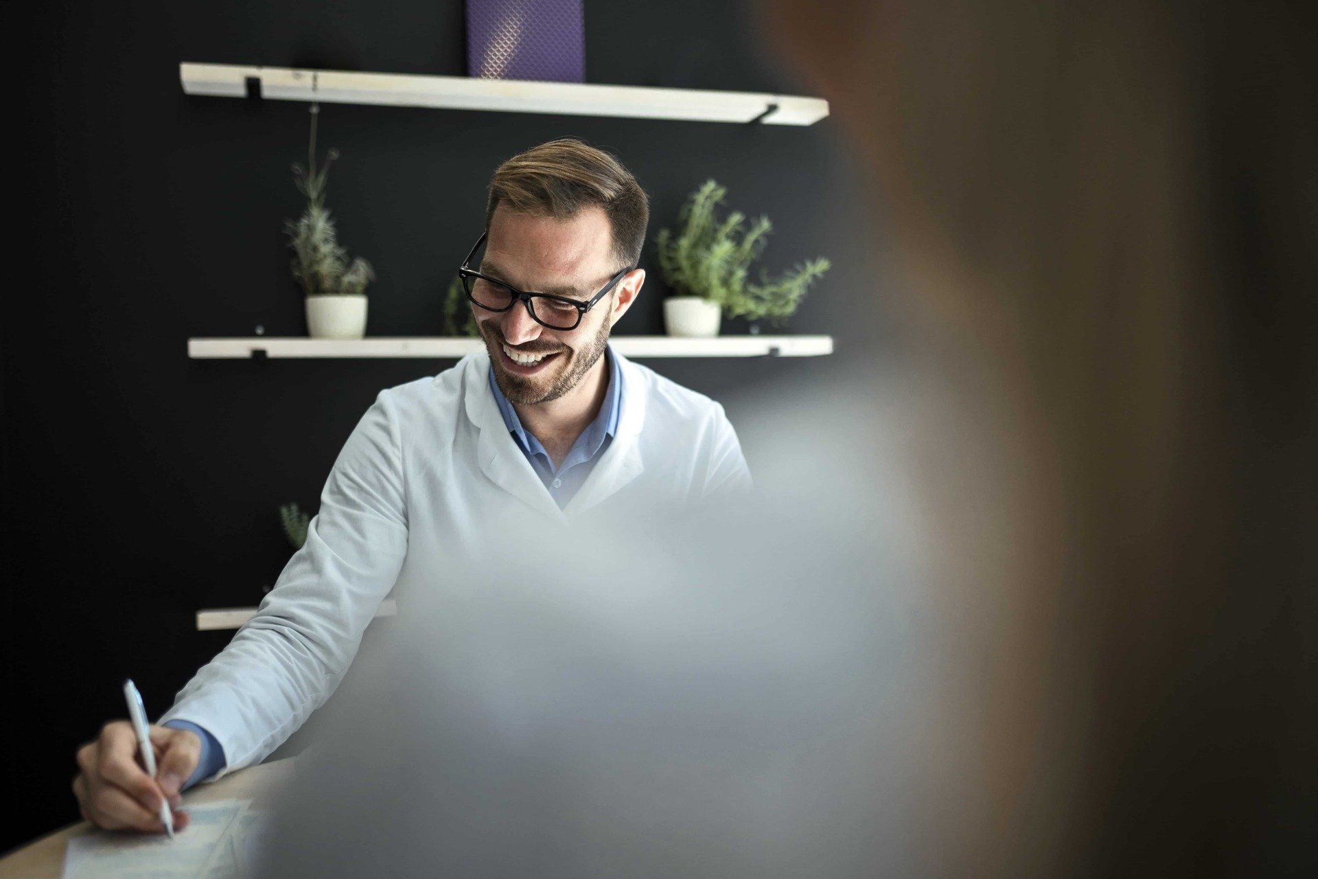 Lachender Wissenschaftler in weißem Kittel