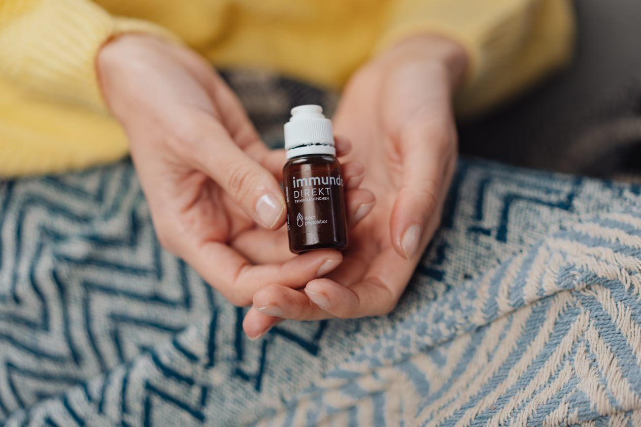 Frauenhände halten immundoc Fläschchen in der Hand
