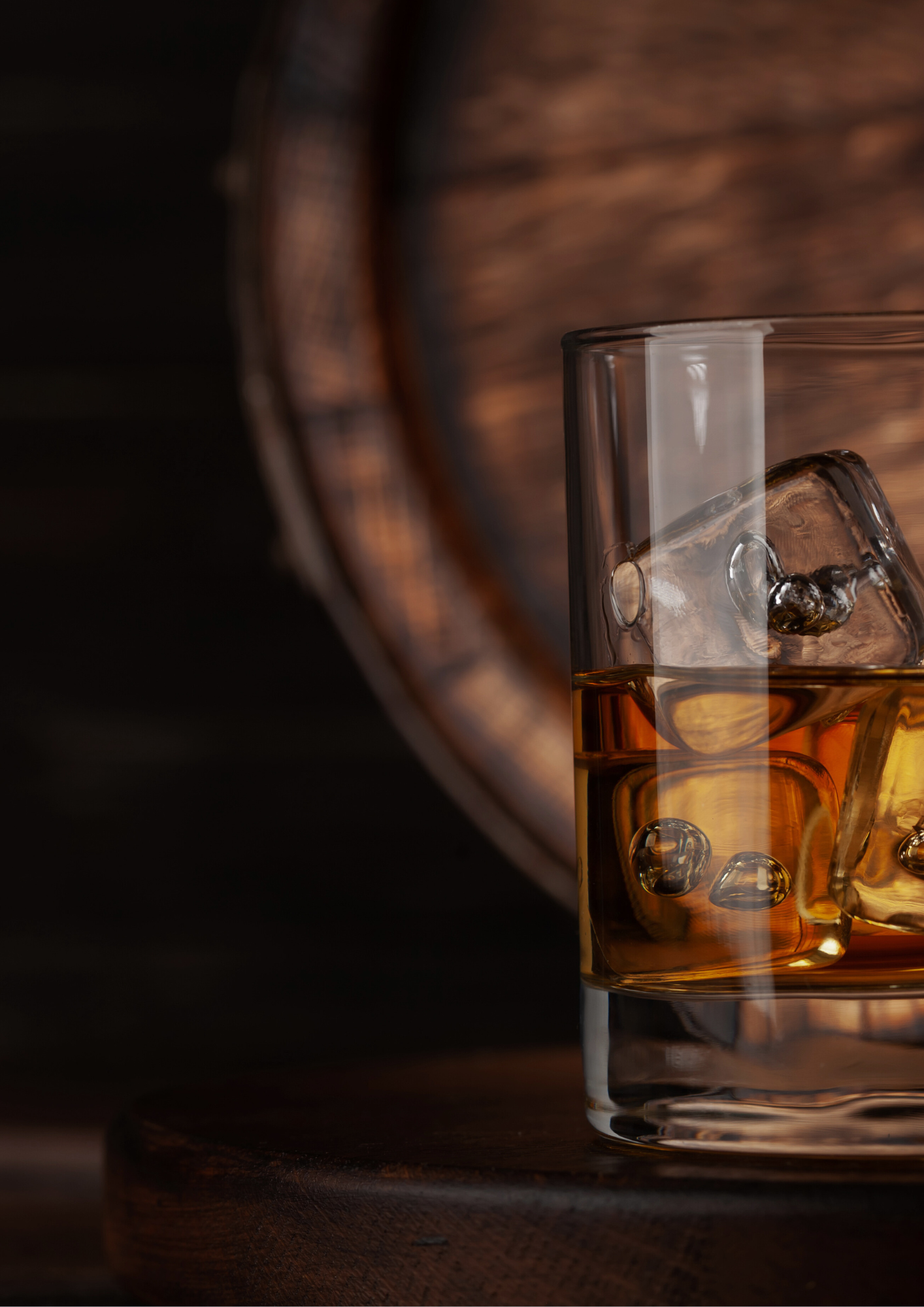 Ein Whiskyglas vor einem Fass