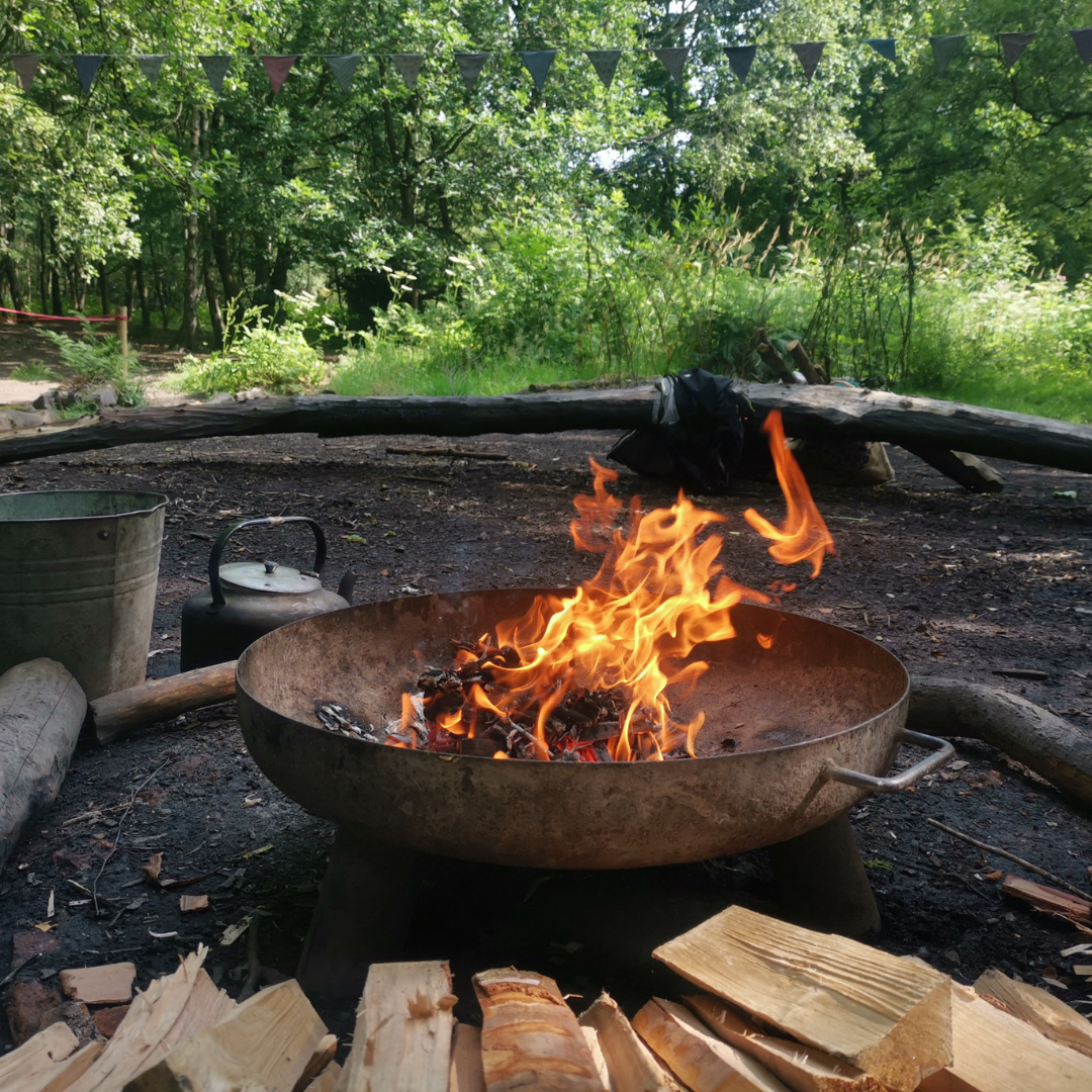 A lit fire pit with flames  in fire square