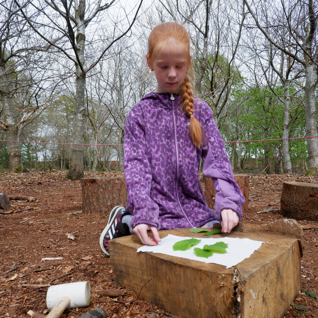 Child creating leaf print using hape zome technique